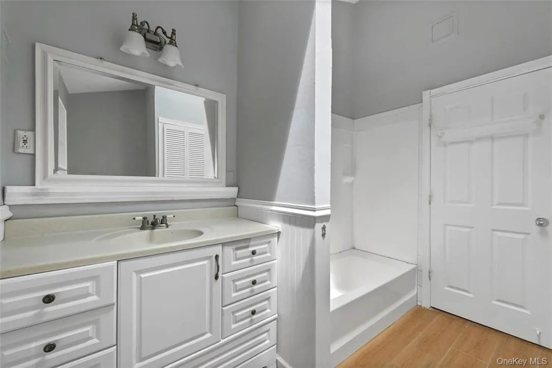 Bathroom with wood-type flooring, shower / tub combination, and vanity Bathroom with wood-type flooring, shower / tub combination, and vanity