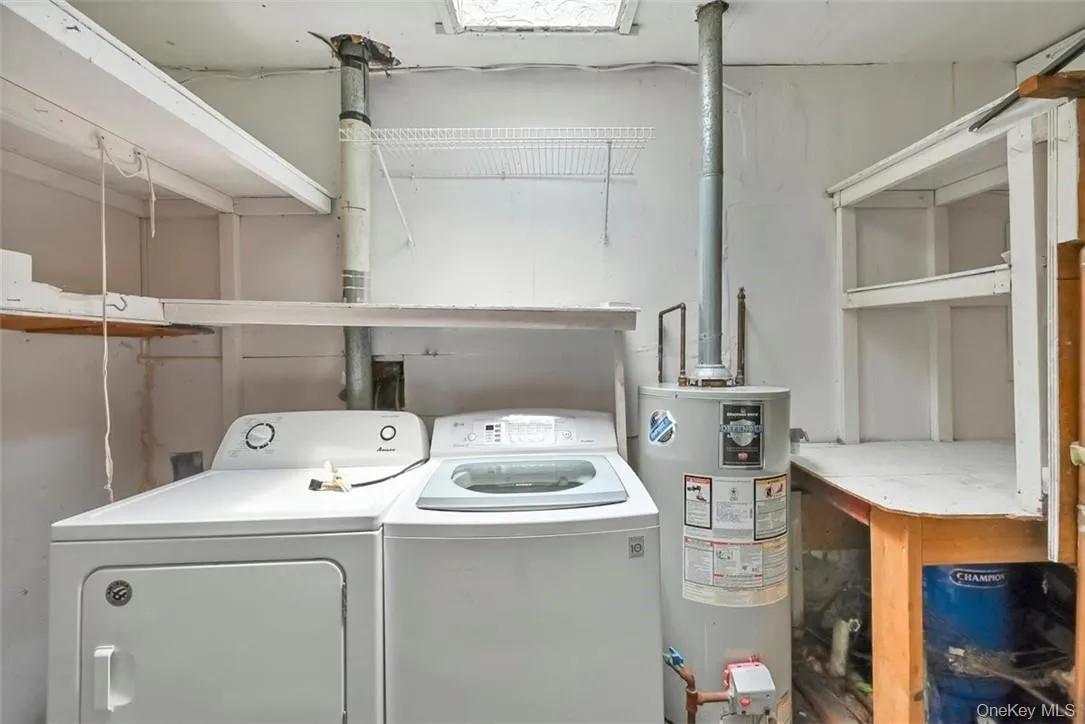 Washroom featuring washing machine and dryer and water heater Washroom featuring washing machine and dryer and water heater