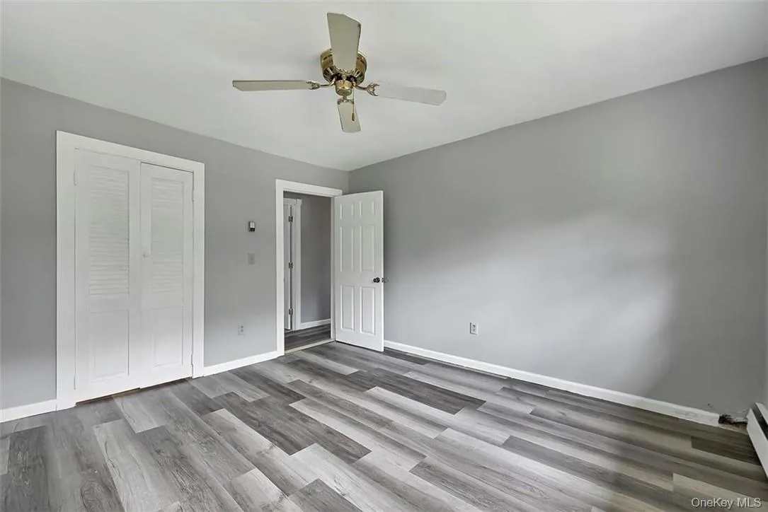 Unfurnished bedroom with a closet, ceiling fan, and hardwood / wood-style floors Unfurnished bedroom with a closet, ceiling fan, and hardwood / wood-style floors