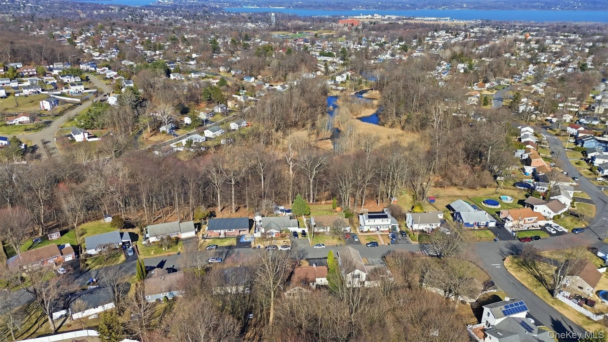 Aerial perspective of suburban area featuring a nearby body of water Aerial perspective of suburban area featuring a nearby body of water