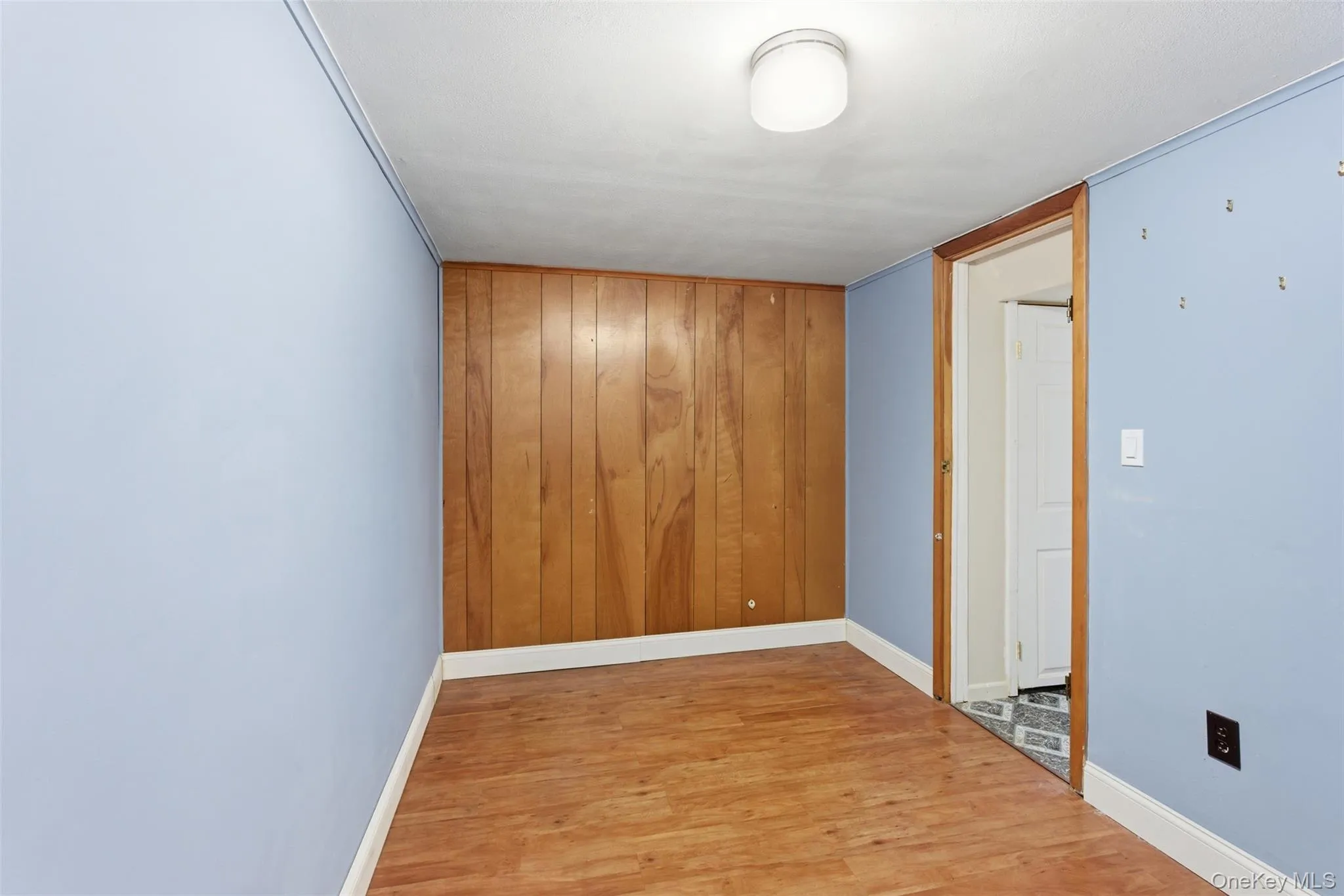 Empty room with light wood finished floors in the basement Empty room with light wood finished floors in the basement