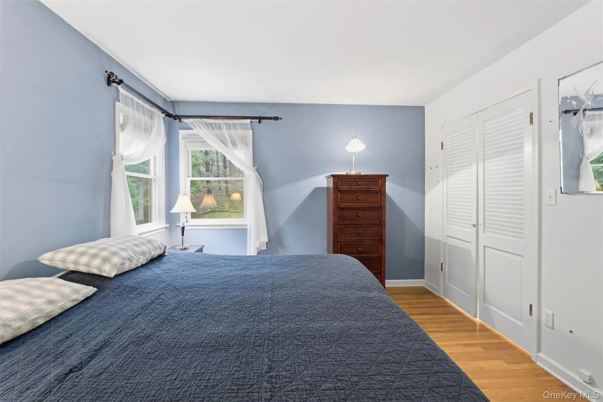 Bedroom featuring light wood finished floors and shelving in the closet Bedroom featuring light wood finished floors and shelving in the closet