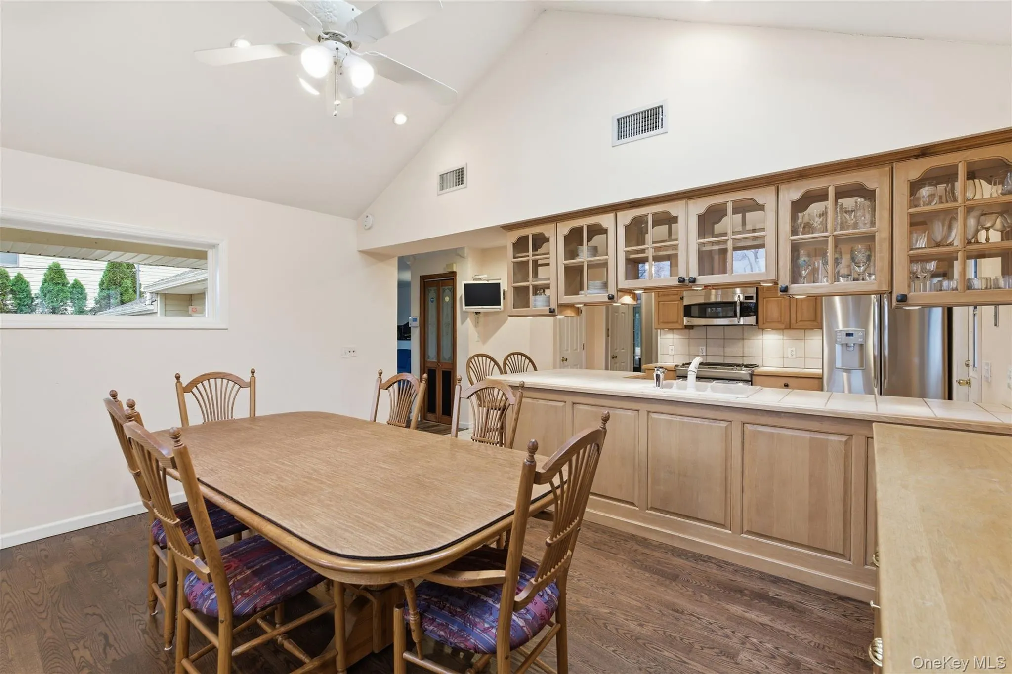 Dining room with lofted ceiling, a ceiling fan, dark wood finished floors, and recessed lighting Dining room with lofted ceiling, a ceiling fan, dark wood finished floors, and recessed lighting