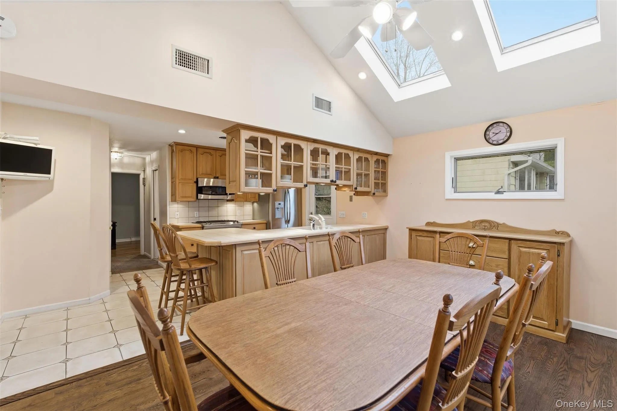Dining room featuring a ceiling fan, vaulted ceiling, light wood-type flooring, a skylight, and recessed lighting Dining room featuring a ceiling fan, vaulted ceiling, light wood-type flooring, a skylight, and recessed lighting