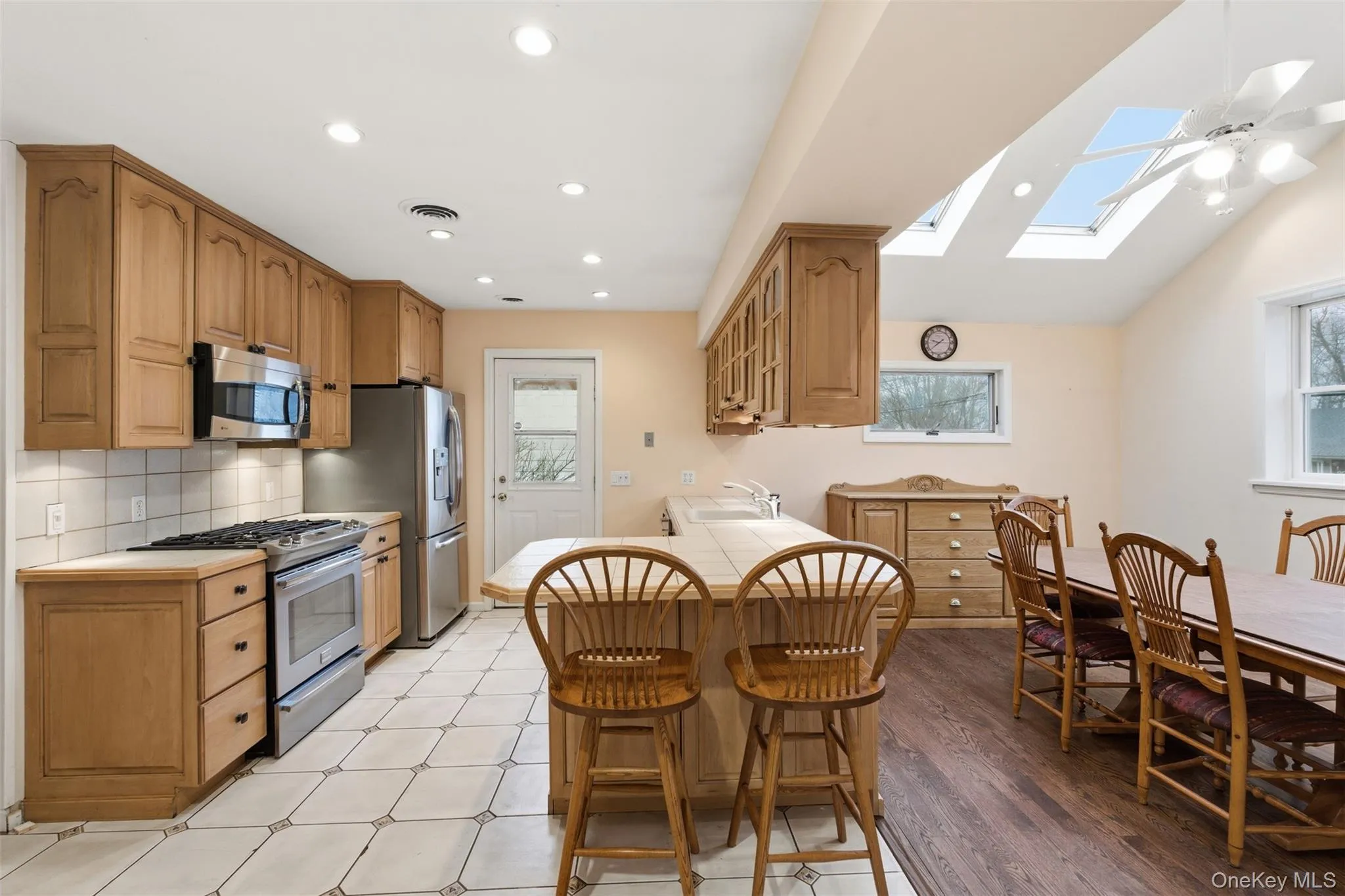 Kitchen featuring a kitchen breakfast bar, stainless steel appliances, recessed lighting, backsplash, and wood finish cabinets Kitchen featuring a kitchen breakfast bar, stainless steel appliances, recessed lighting, backsplash, and wood finish cabinets
