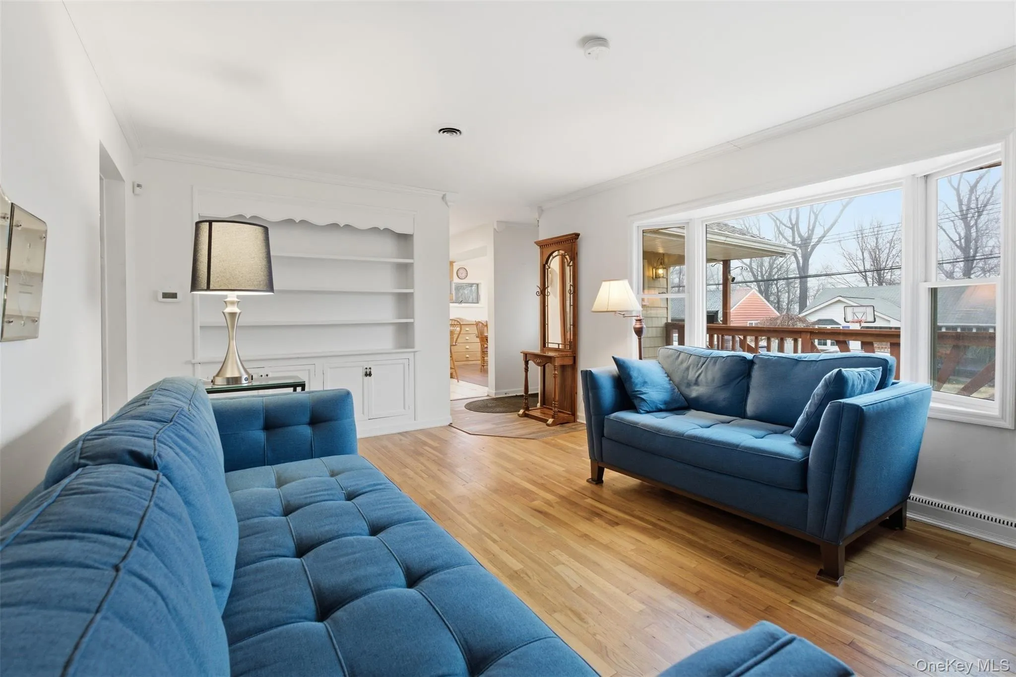 Living area with light wood-style floors, built in features, and crown molding Living area with light wood-style floors, built in features, and crown molding