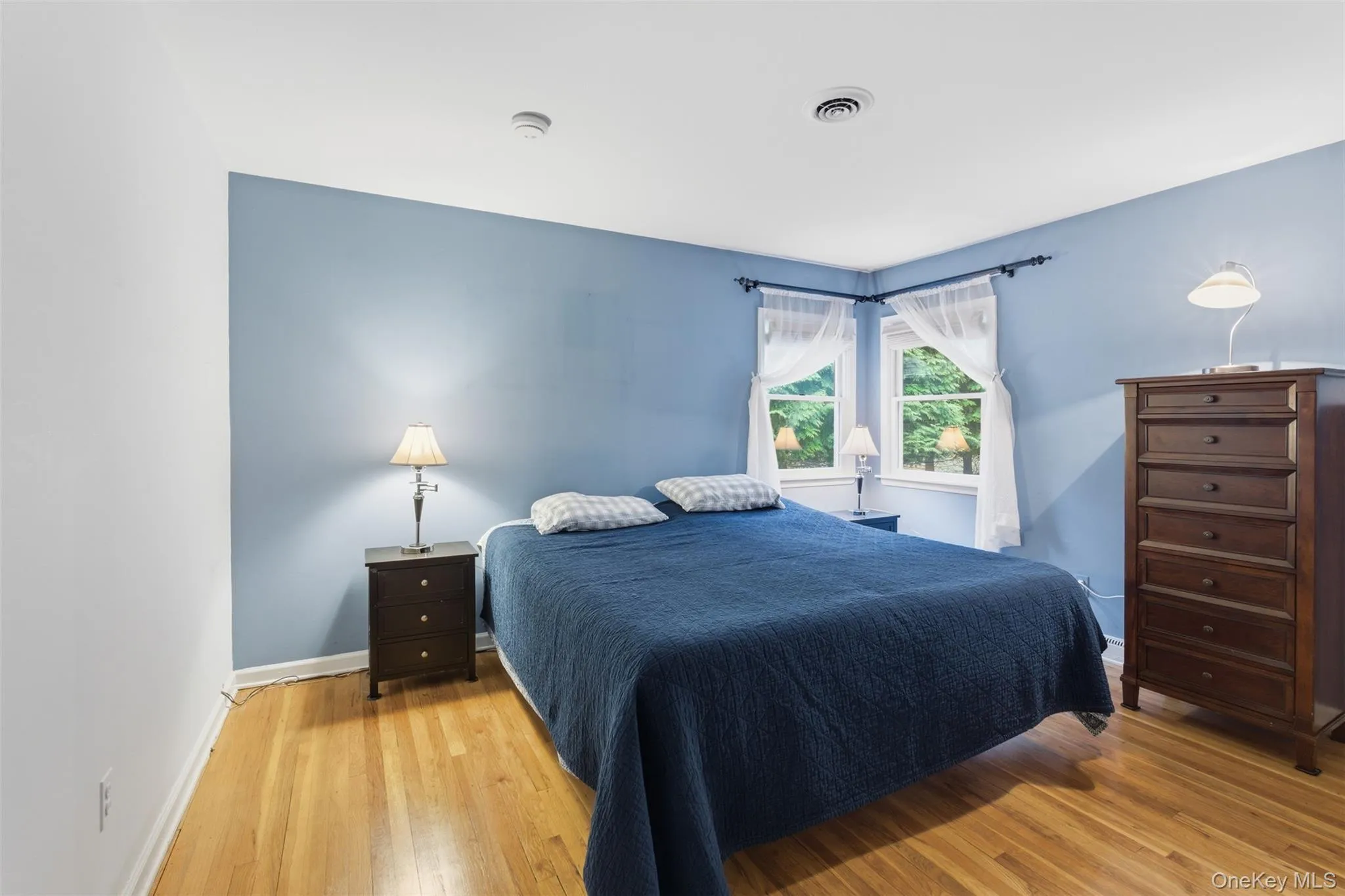 Bedroom featuring light wood finished floors and baseboards Bedroom featuring light wood finished floors and baseboards