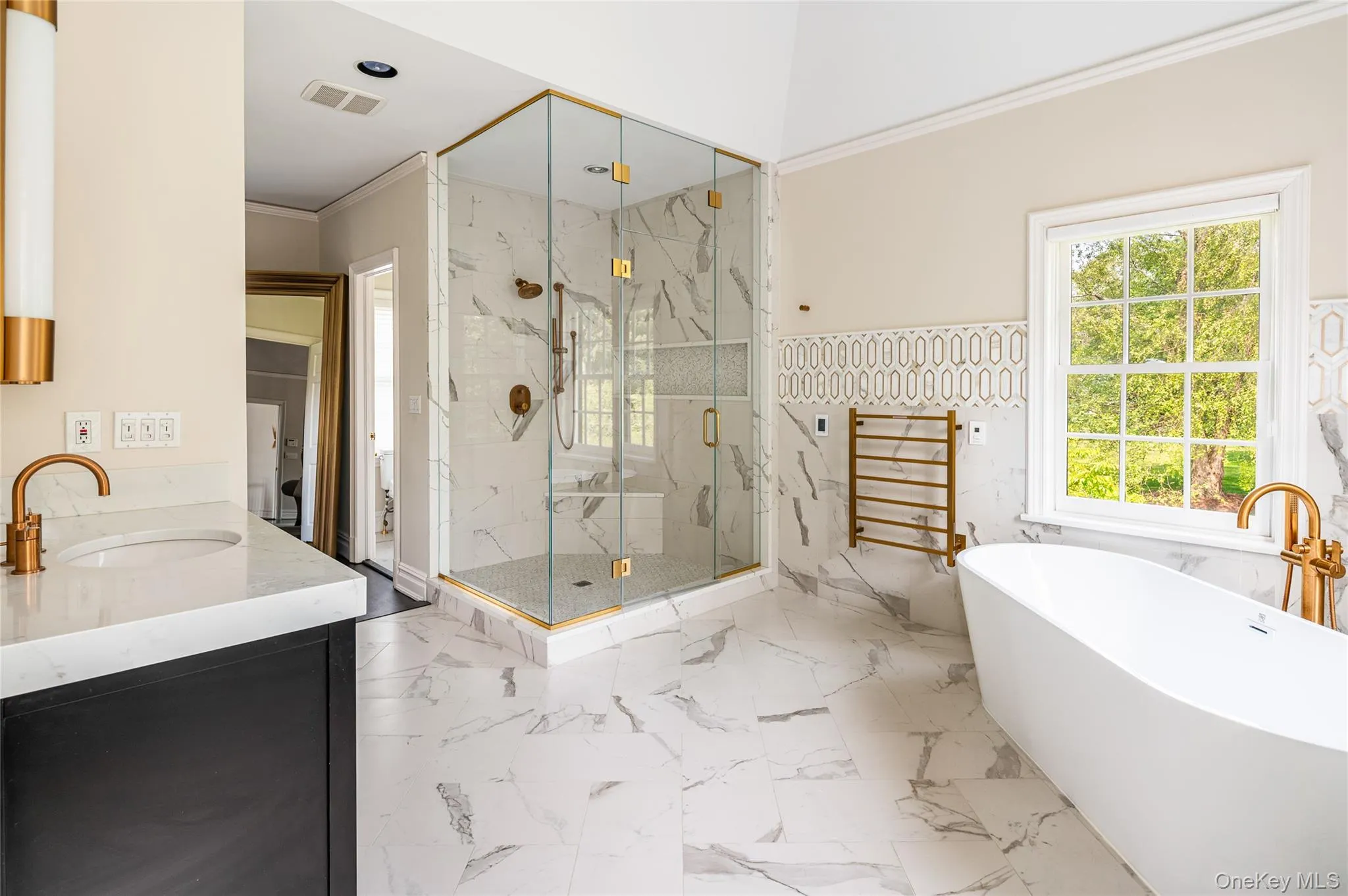 Bathroom featuring a marble finish shower, a soaking tub, crown molding, vanity, and marble finish flooring Bathroom featuring a marble finish shower, a soaking tub, crown molding, vanity, and marble finish flooring