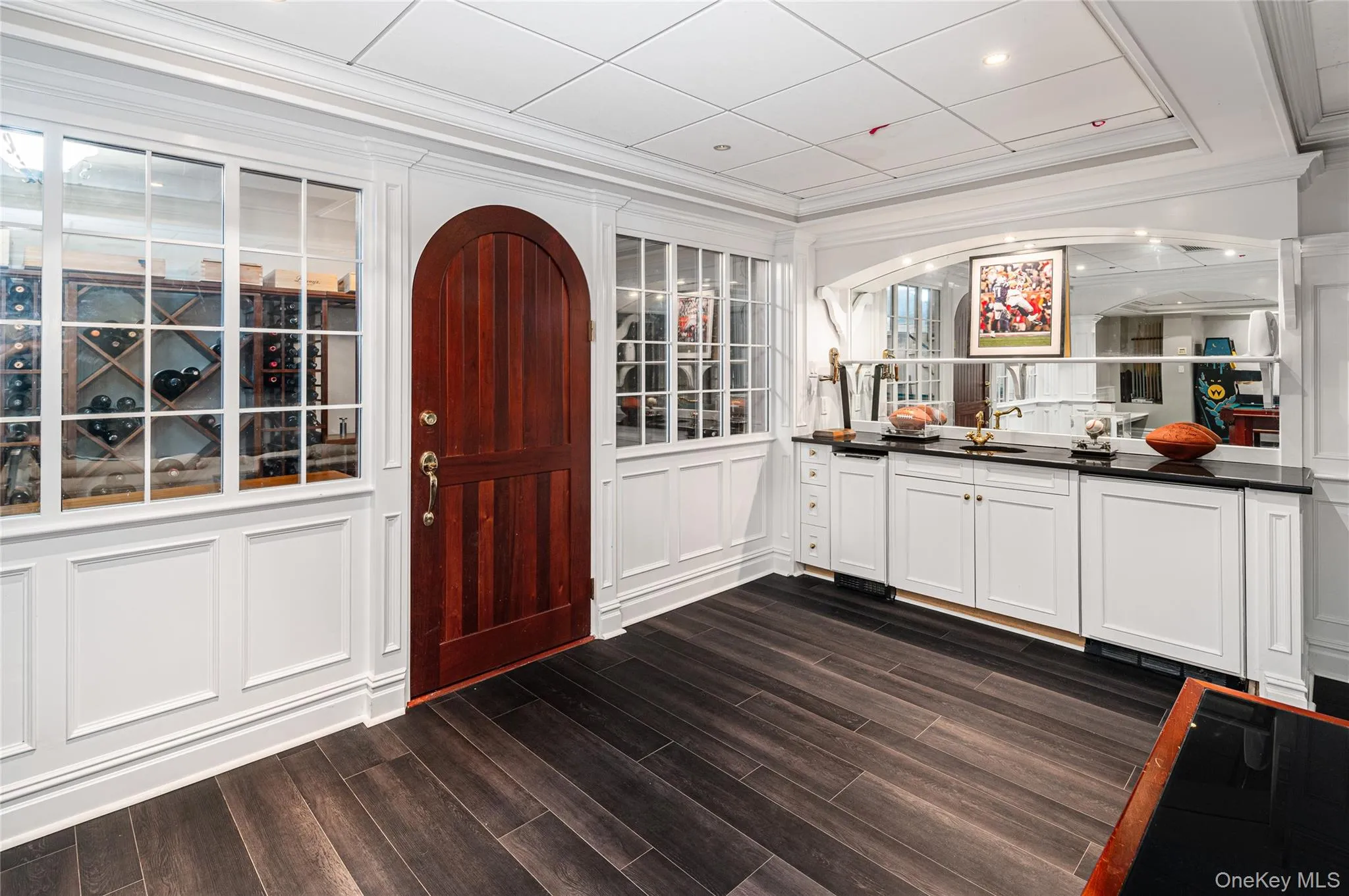 Bar with crown molding, a decorative wall, and dark wood-type flooring Bar with crown molding, a decorative wall, and dark wood-type flooring