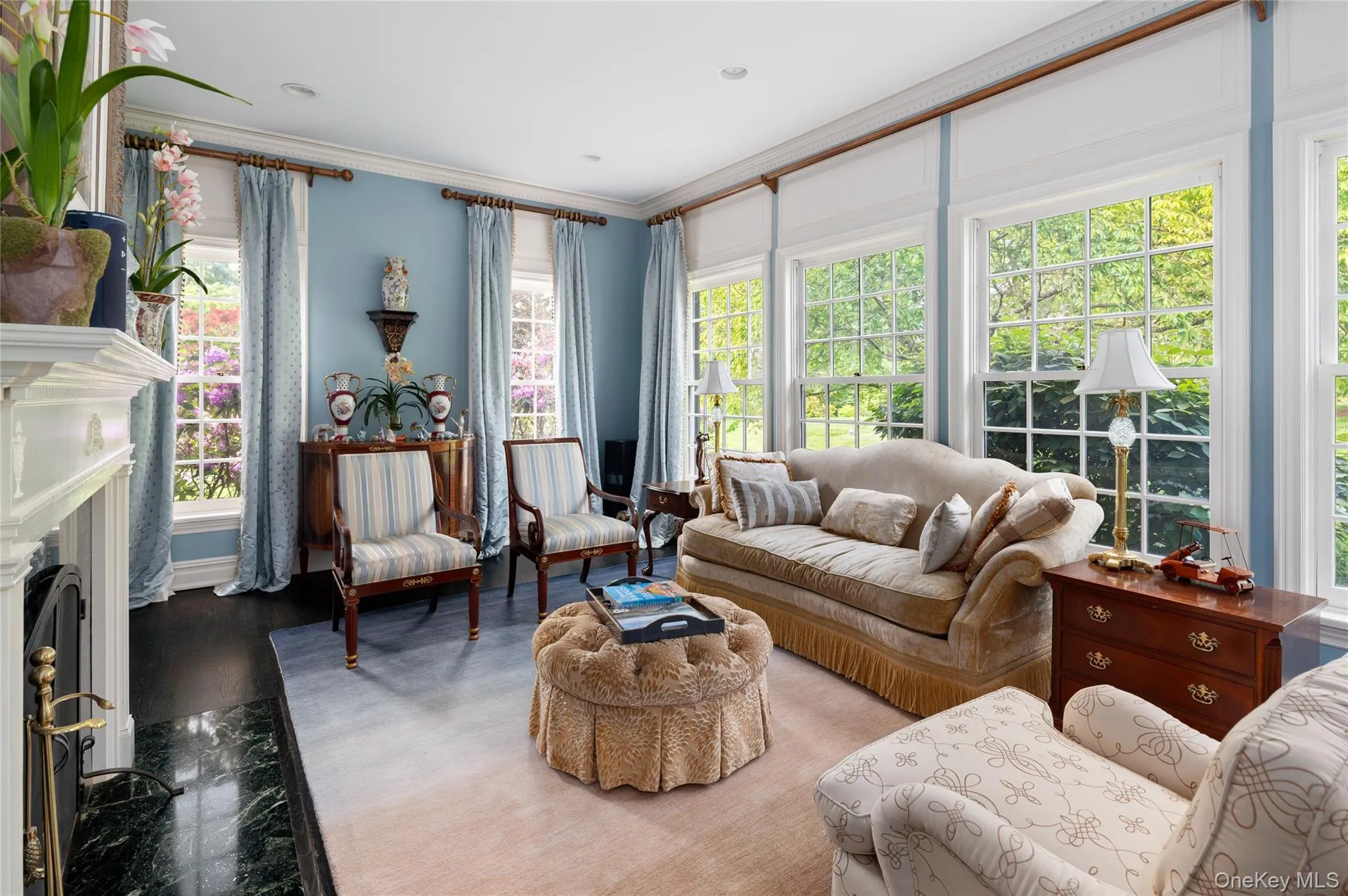 Living area featuring ornamental molding, wood finished floors, and a fireplace Living area featuring ornamental molding, wood finished floors, and a fireplace
