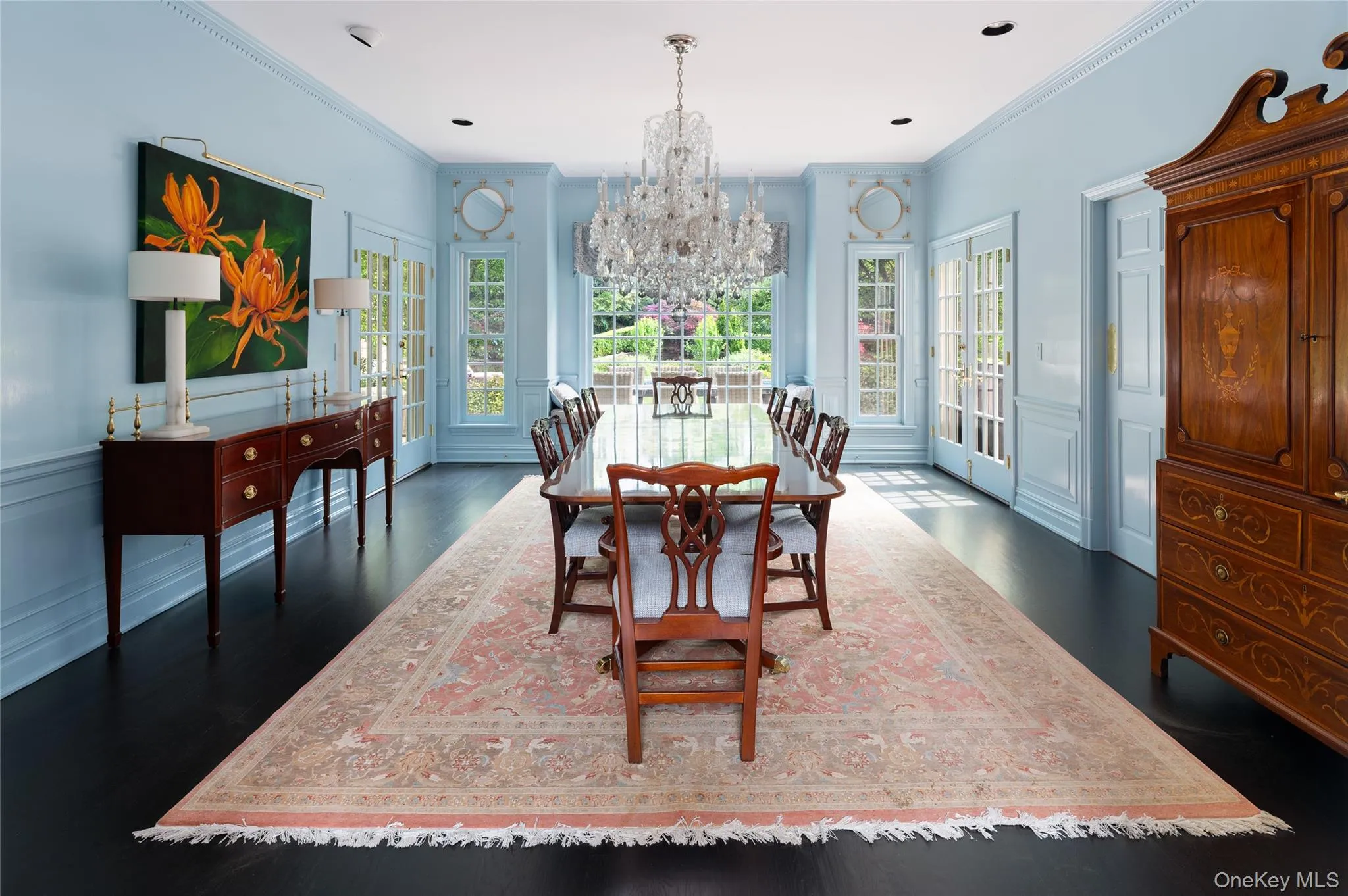 Dining area featuring a chandelier, dark wood-style floors, crown molding, a decorative wall, and wainscoting Dining area featuring a chandelier, dark wood-style floors, crown molding, a decorative wall, and wainscoting