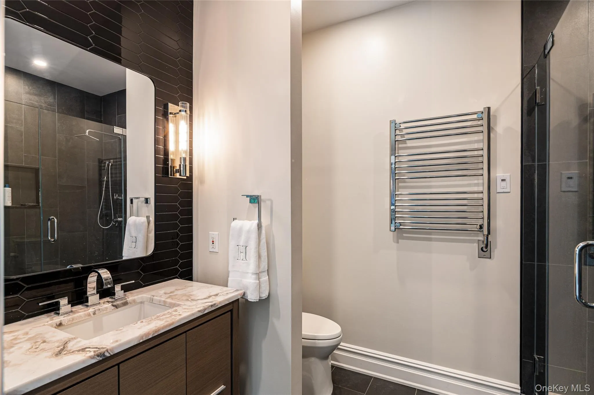 Bathroom featuring radiator heating unit, vanity, tile patterned flooring, a shower stall, and toilet Bathroom featuring radiator heating unit, vanity, tile patterned flooring, a shower stall, and toilet