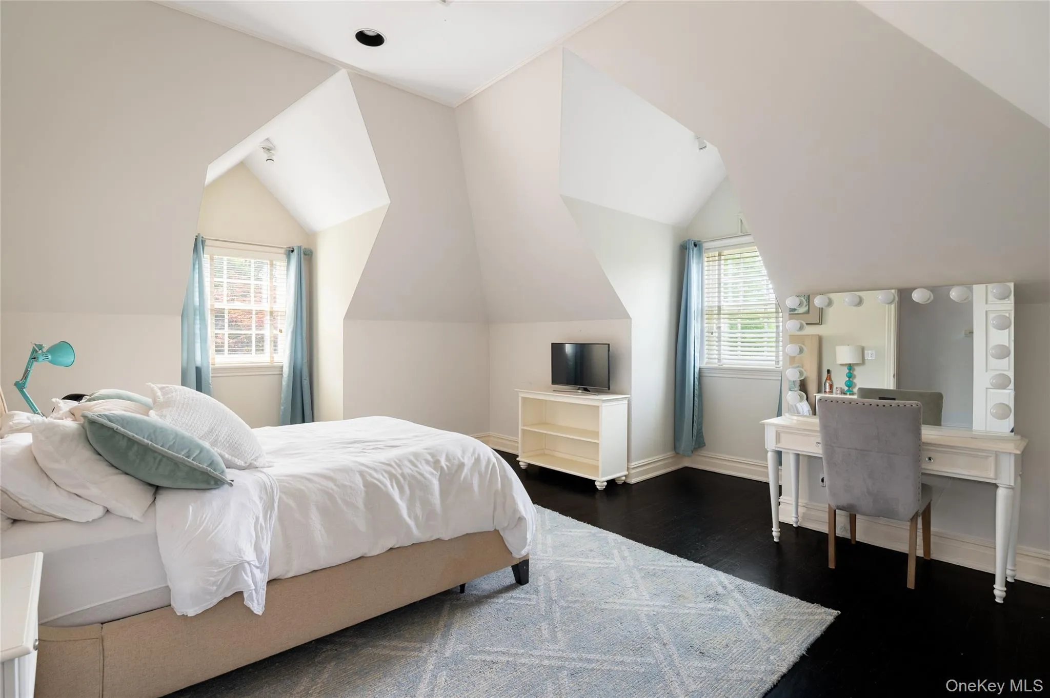 Bedroom with dark wood finished floors, lofted ceiling, and baseboards Bedroom with dark wood finished floors, lofted ceiling, and baseboards