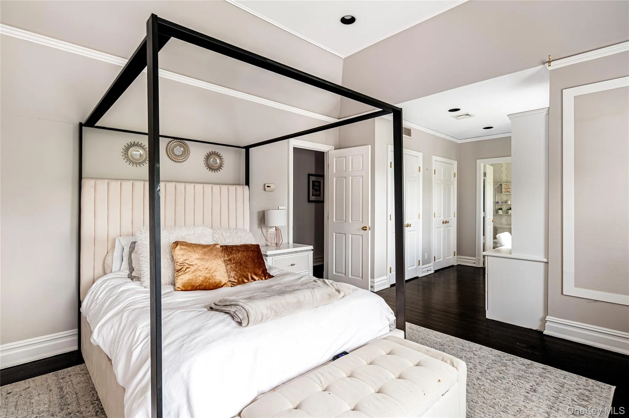 Bedroom featuring ornamental molding, dark wood-style flooring, and baseboards Bedroom featuring ornamental molding, dark wood-style flooring, and baseboards