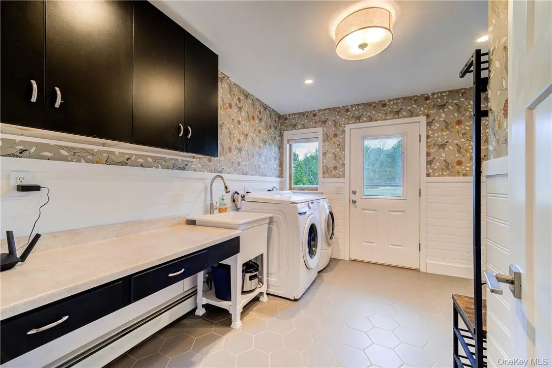 Storage cabinets, a sink and massive folding table make this mud/room - laundry center a terrific space! It also offers direct access right to the backyard! Storage cabinets, a sink and massive folding table make this mud/room - laundry center a terrific space! It also offers direct access right to the backyard!