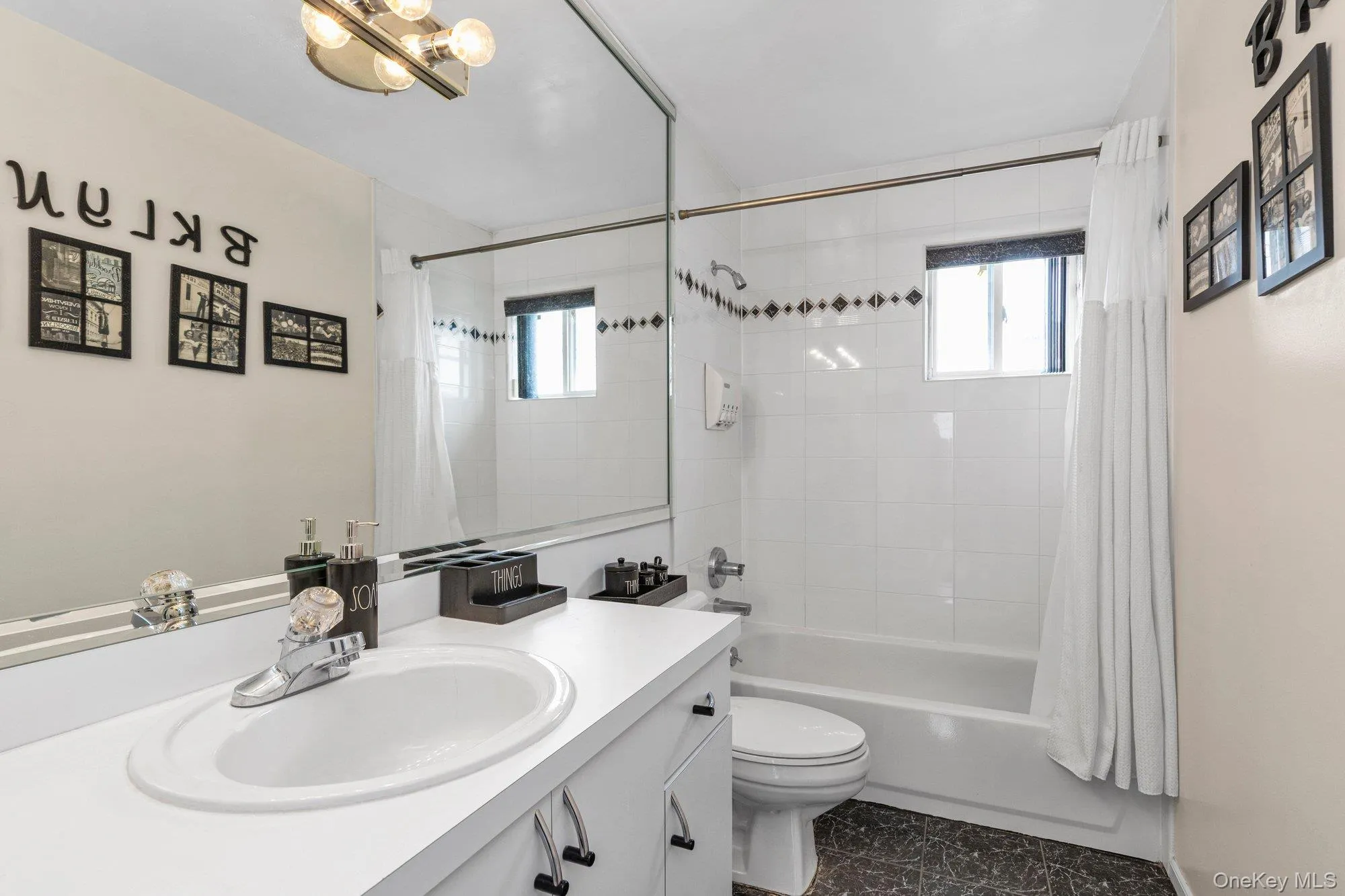 Bathroom with vanity, shower / bath combination with curtain, and suspended lighting Bathroom with vanity, shower / bath combination with curtain, and suspended lighting