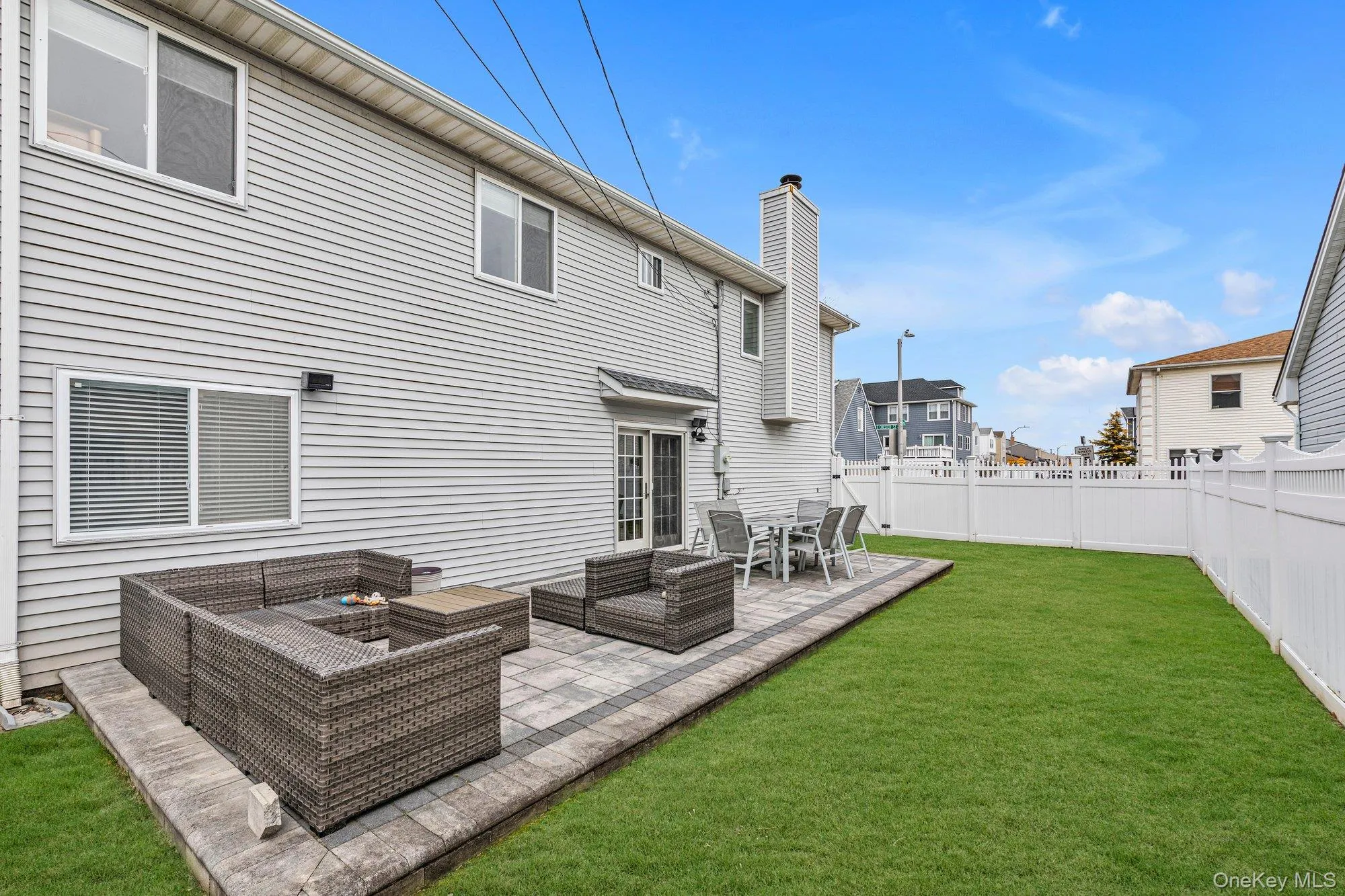 Rear view of house with a wooden deck, outdoor furniture, a fenced backyard, and a chimney Rear view of house with a wooden deck, outdoor furniture, a fenced backyard, and a chimney