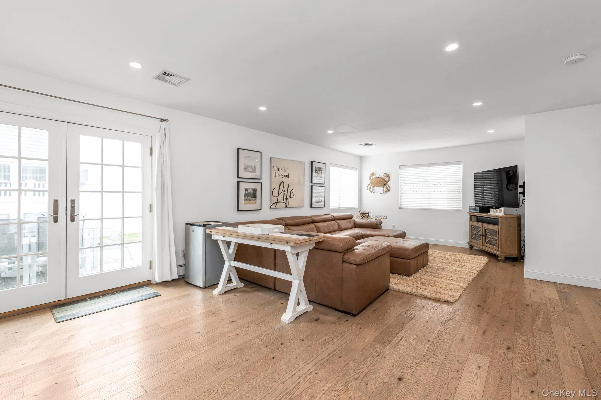 Living area featuring light wood finished floors, french doors, and recessed lighting Living area featuring light wood finished floors, french doors, and recessed lighting