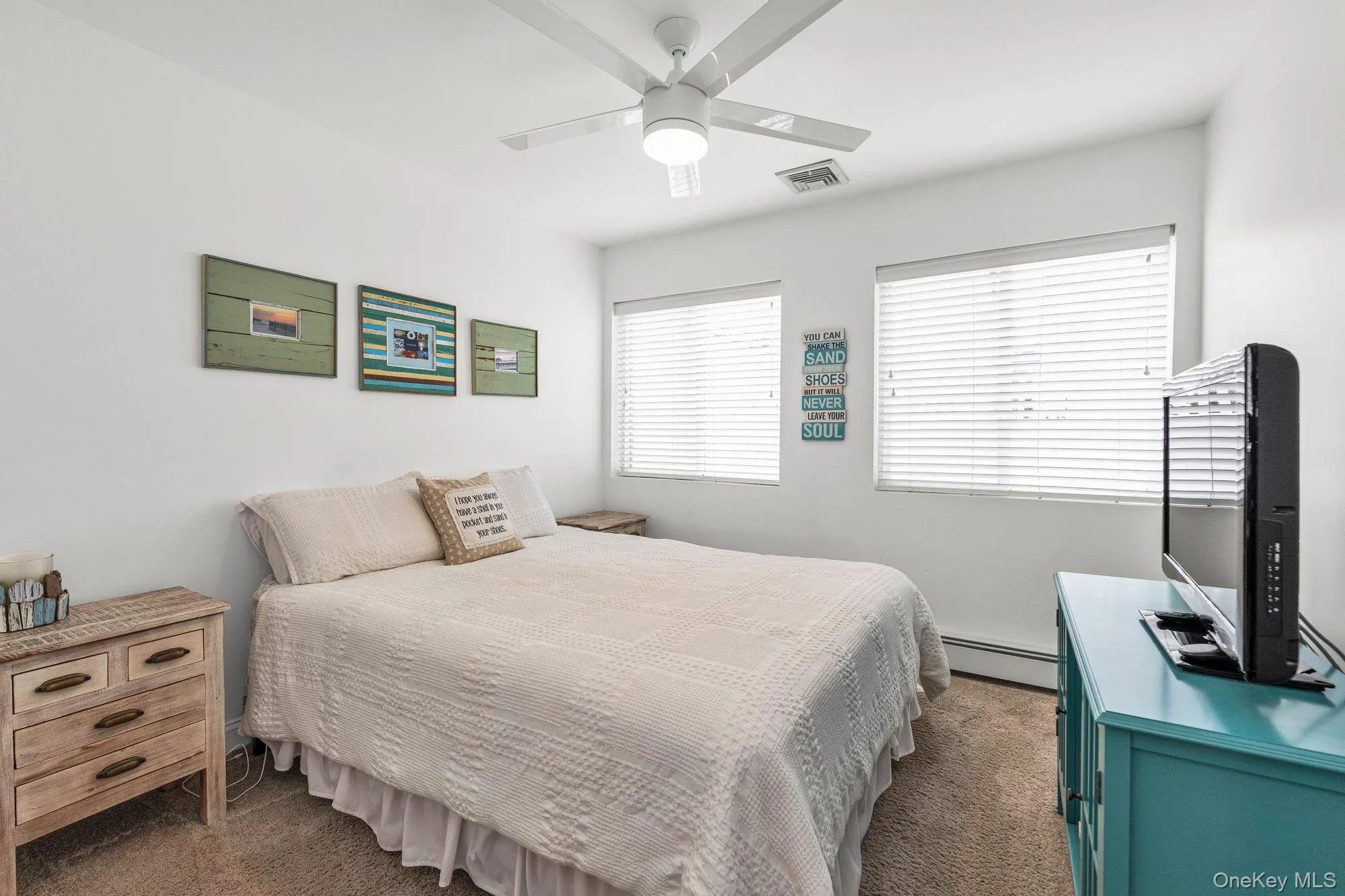 Bedroom featuring dark carpet, a baseboard heating unit, and ceiling fan Bedroom featuring dark carpet, a baseboard heating unit, and ceiling fan