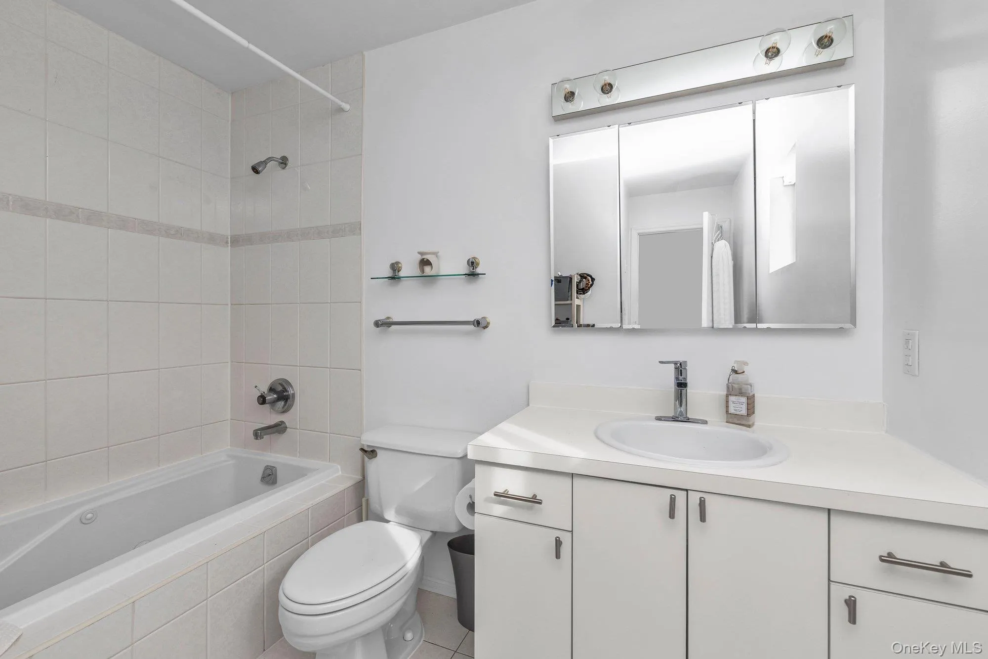 Bathroom with vanity, tiled shower / bath, and light tile patterned floors Bathroom with vanity, tiled shower / bath, and light tile patterned floors