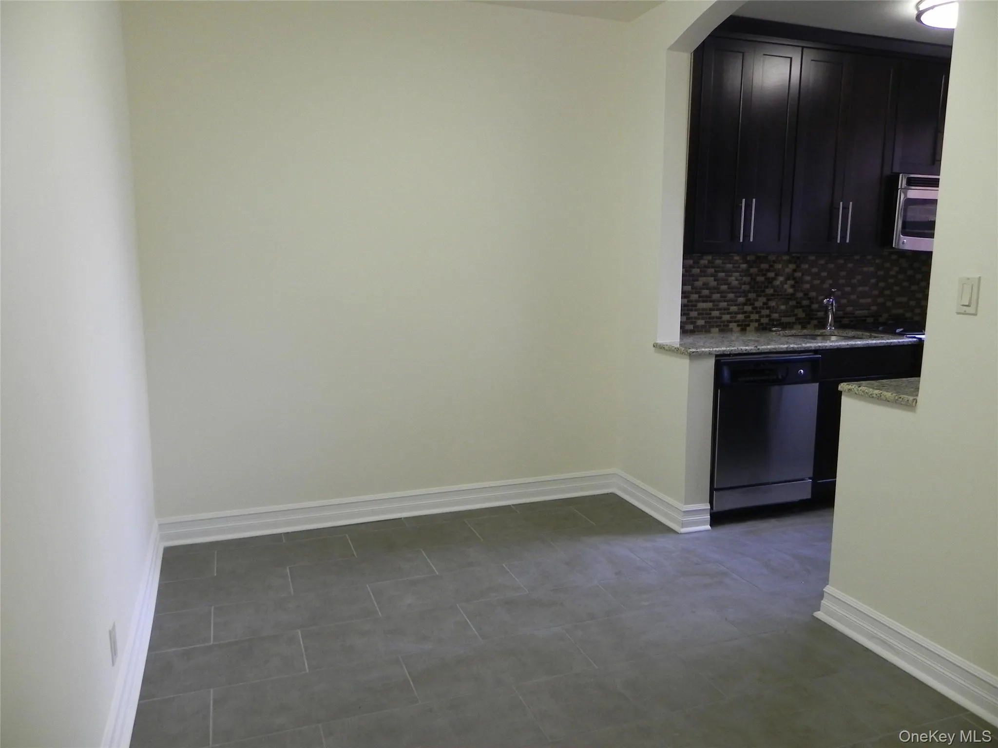 Kitchen with light stone counters, tile backsplash, and stainless steel appliances Kitchen with light stone counters, tile backsplash, and stainless steel appliances