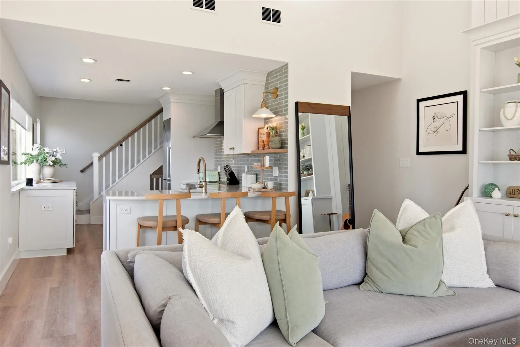 Breakfast area into living room with vaulted ceilings, wood-burning fireplace, and water views. Breakfast area into living room with vaulted ceilings, wood-burning fireplace, and water views.