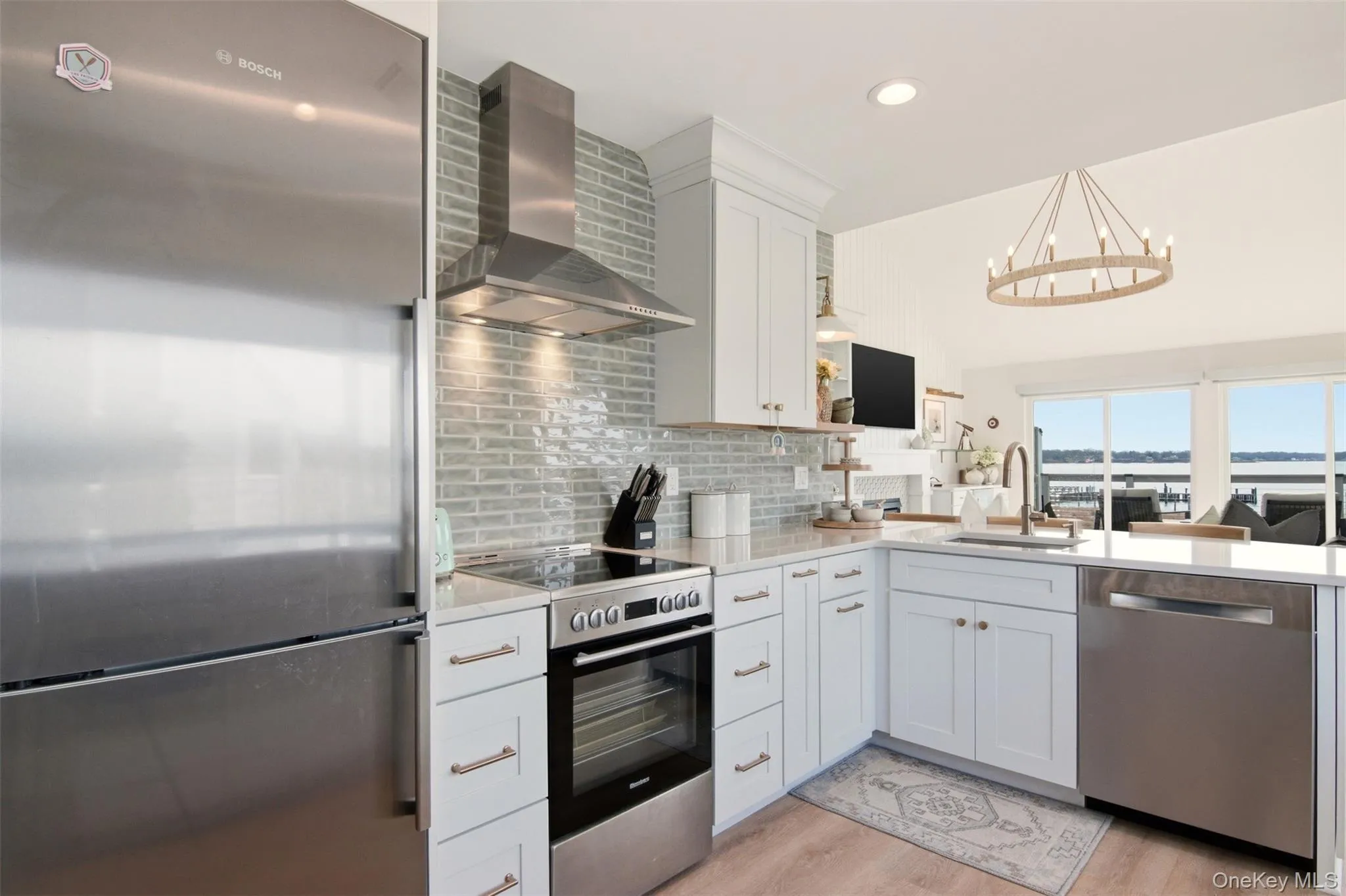 New kitchen with incredible views. Stainless steel appliances, white cabinetry, light wood-style floors, quartz counters, vaulted ceiling, and recessed lighting New kitchen with incredible views. Stainless steel appliances, white cabinetry, light wood-style floors, quartz counters, vaulted ceiling, and recessed lighting