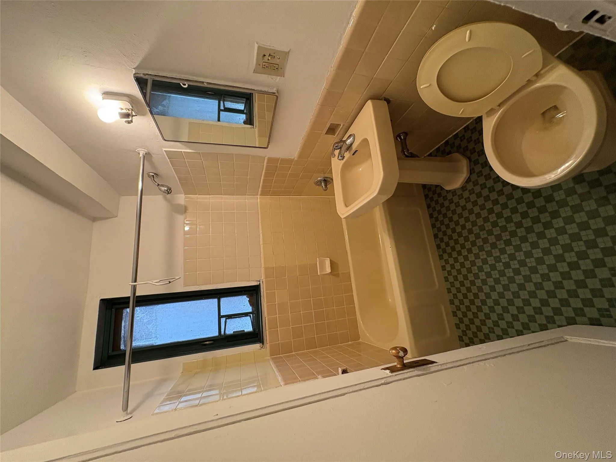 Bathroom featuring tile walls, a wainscoted wall, bathtub / shower combination, and dark floors Bathroom featuring tile walls, a wainscoted wall, bathtub / shower combination, and dark floors