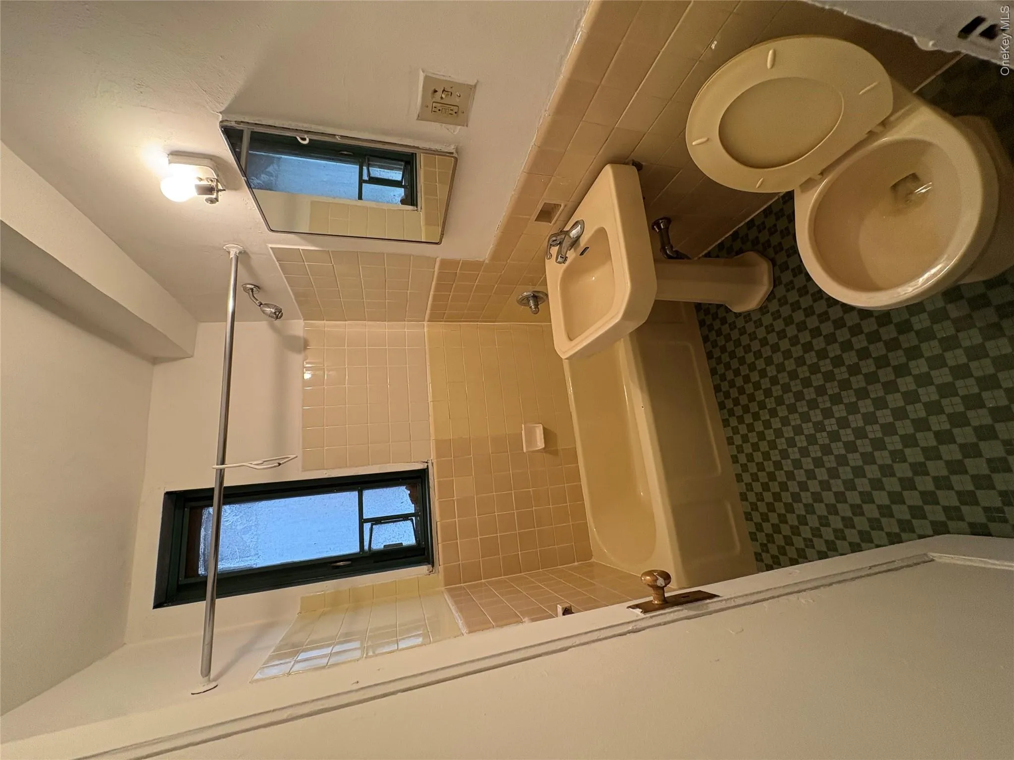 Bathroom featuring tile walls, a wainscoted wall, bathtub / shower combination, and dark floors Bathroom featuring tile walls, a wainscoted wall, bathtub / shower combination, and dark floors