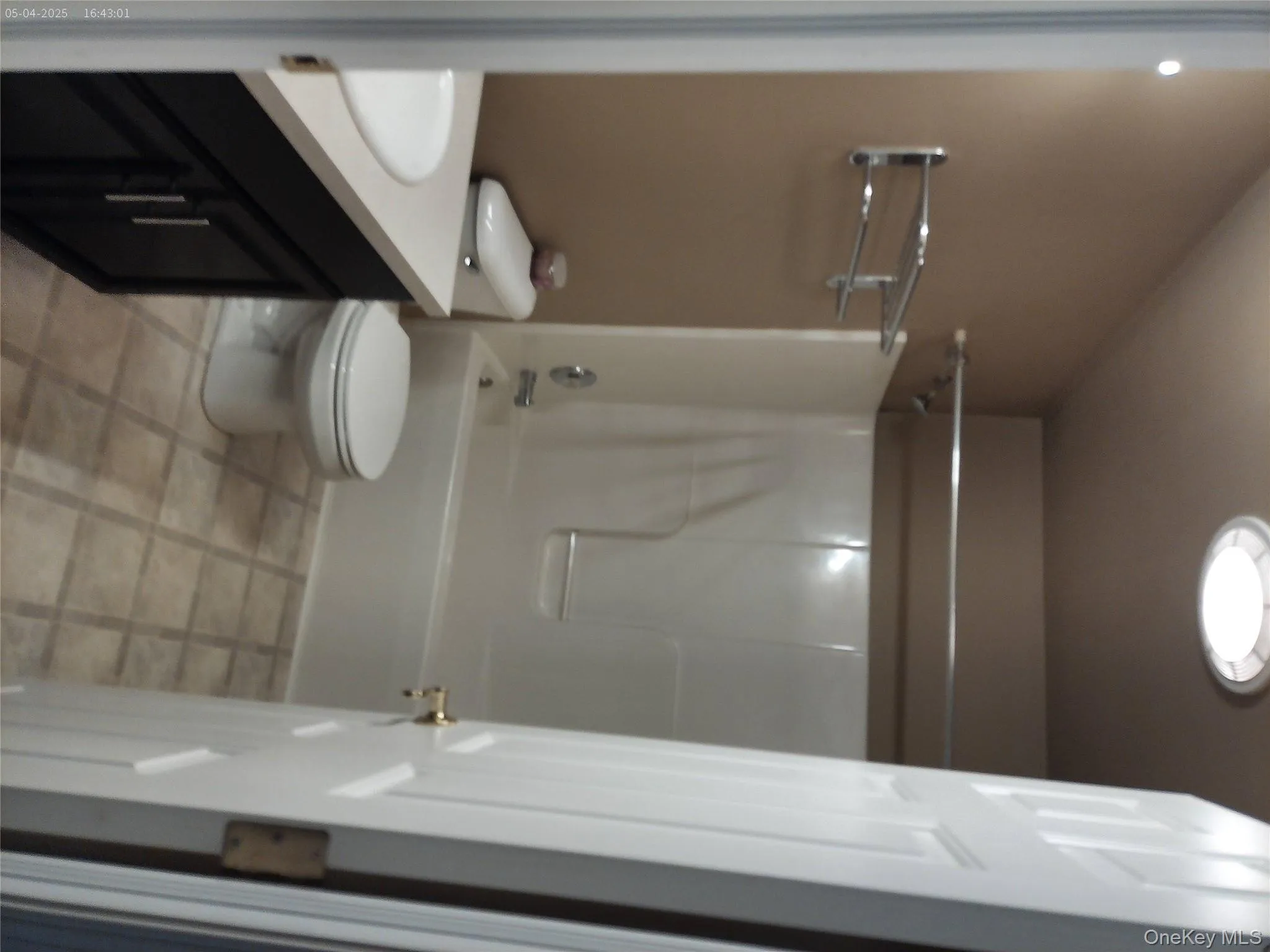 Bathroom featuring toilet, vanity, and washtub / shower combination Bathroom featuring toilet, vanity, and washtub / shower combination