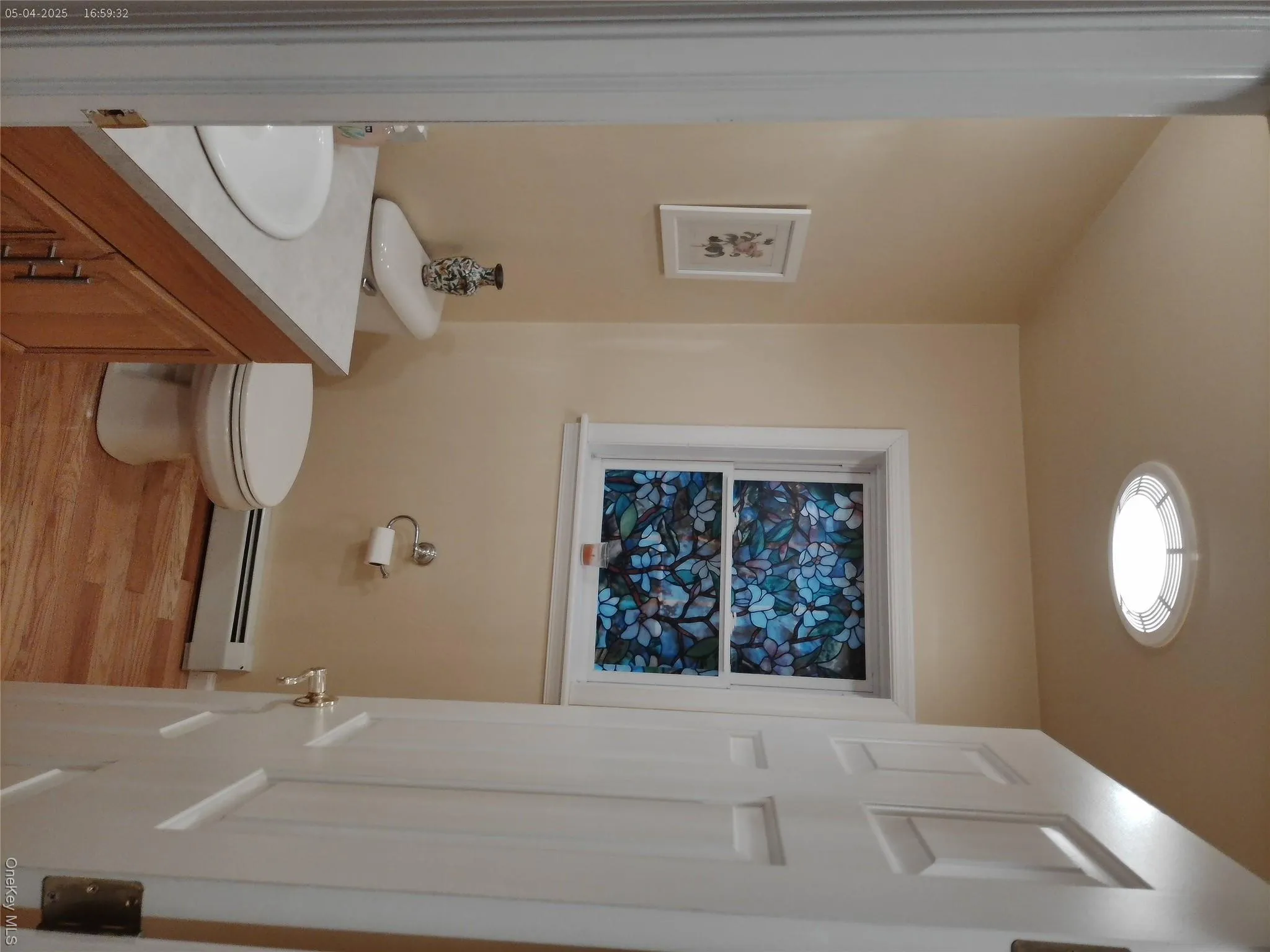 Bathroom with a baseboard radiator, wood finished floors, toilet, and vanity Bathroom with a baseboard radiator, wood finished floors, toilet, and vanity