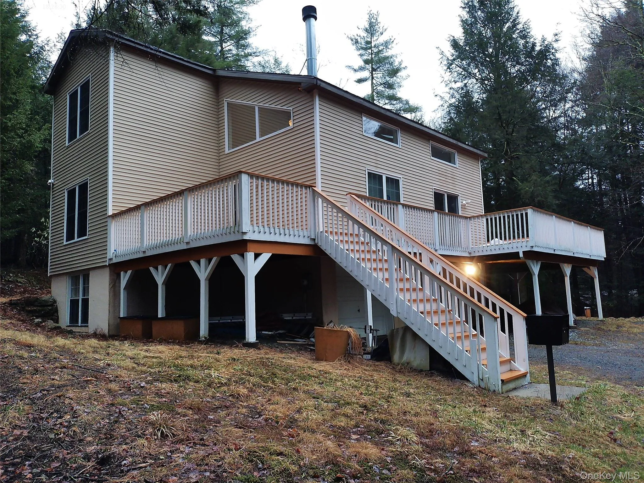 Rear view of property with stairs and a wooden deck Rear view of property with stairs and a wooden deck