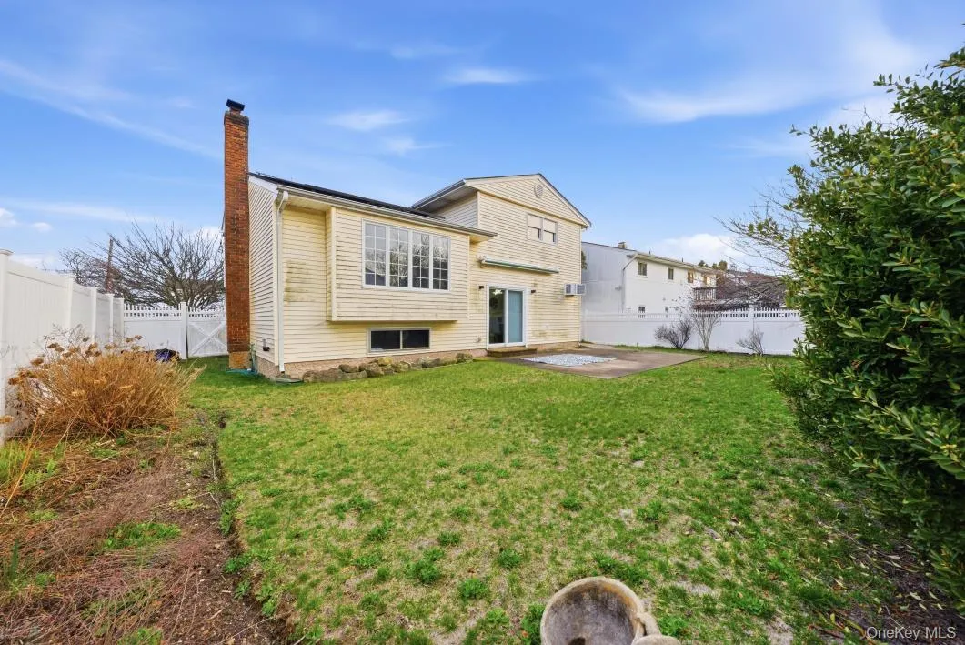 Rear view of house with a patio, a fenced backyard, and a chimney Rear view of house with a patio, a fenced backyard, and a chimney