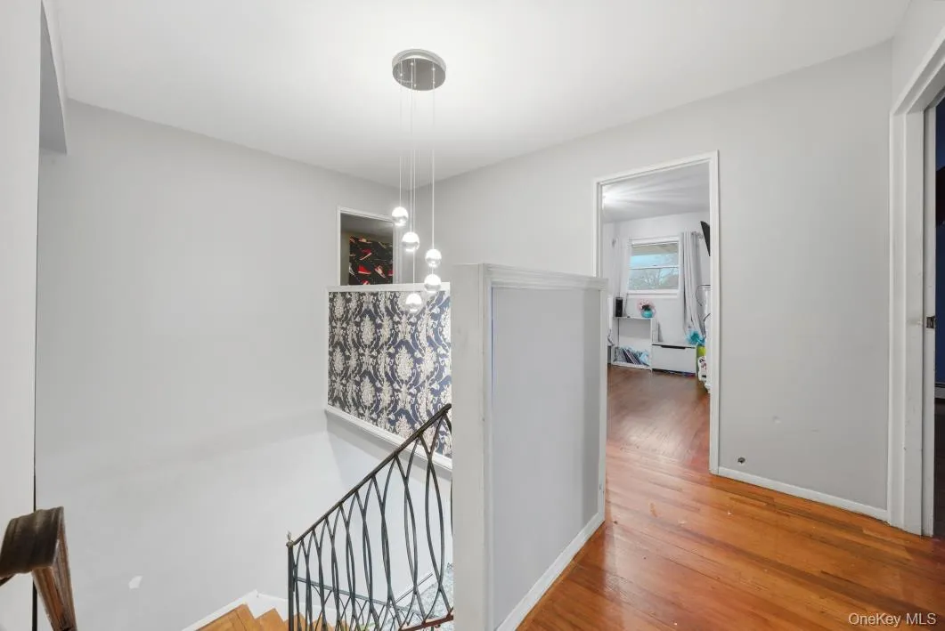 Hallway with an upstairs landing and light wood finished floors Hallway with an upstairs landing and light wood finished floors