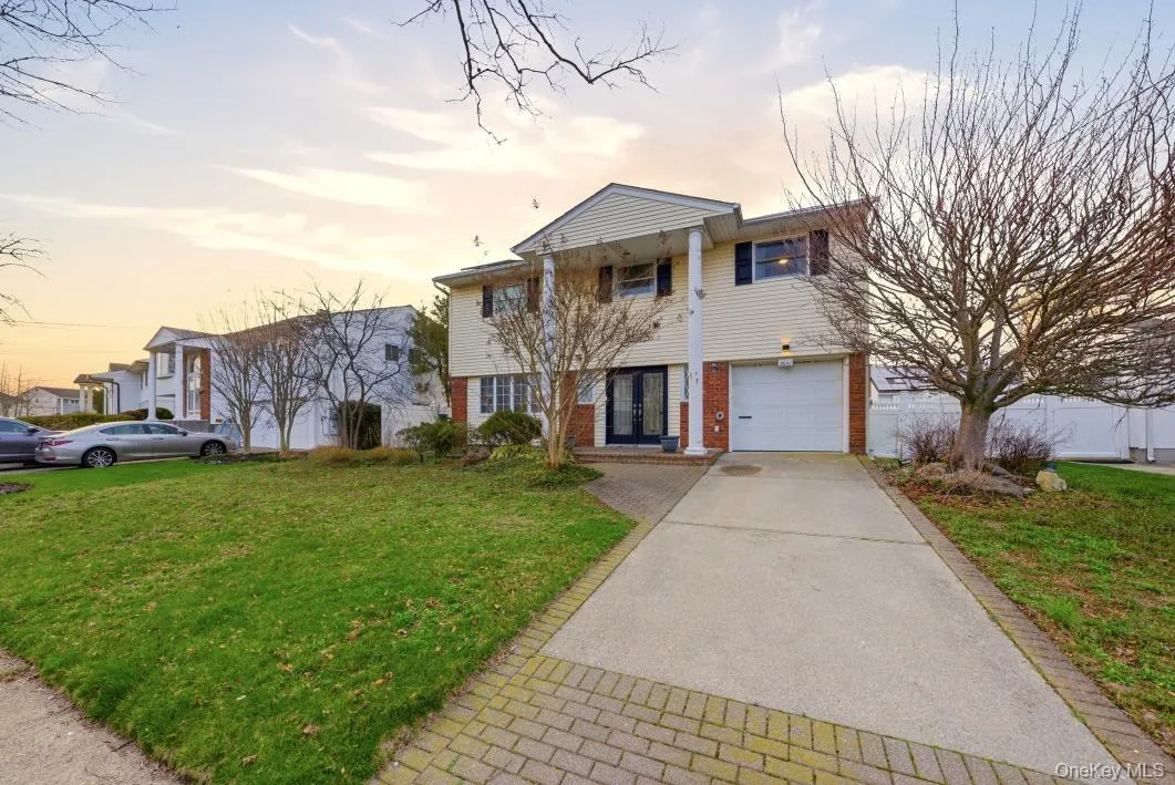 View of front of property featuring a front yard, an attached garage and driveway View of front of property featuring a front yard, an attached garage and driveway