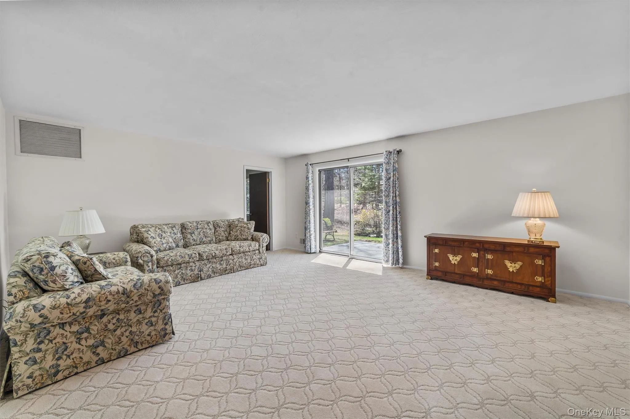 Spacious Living room with carpet flooring and sliders to the patio. Spacious Living room with carpet flooring and sliders to the patio.