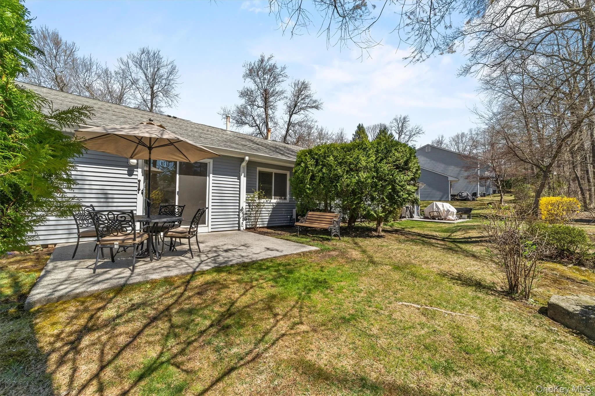 Rear view of condo featuring the patio, and green space. Rear view of condo featuring the patio, and green space.