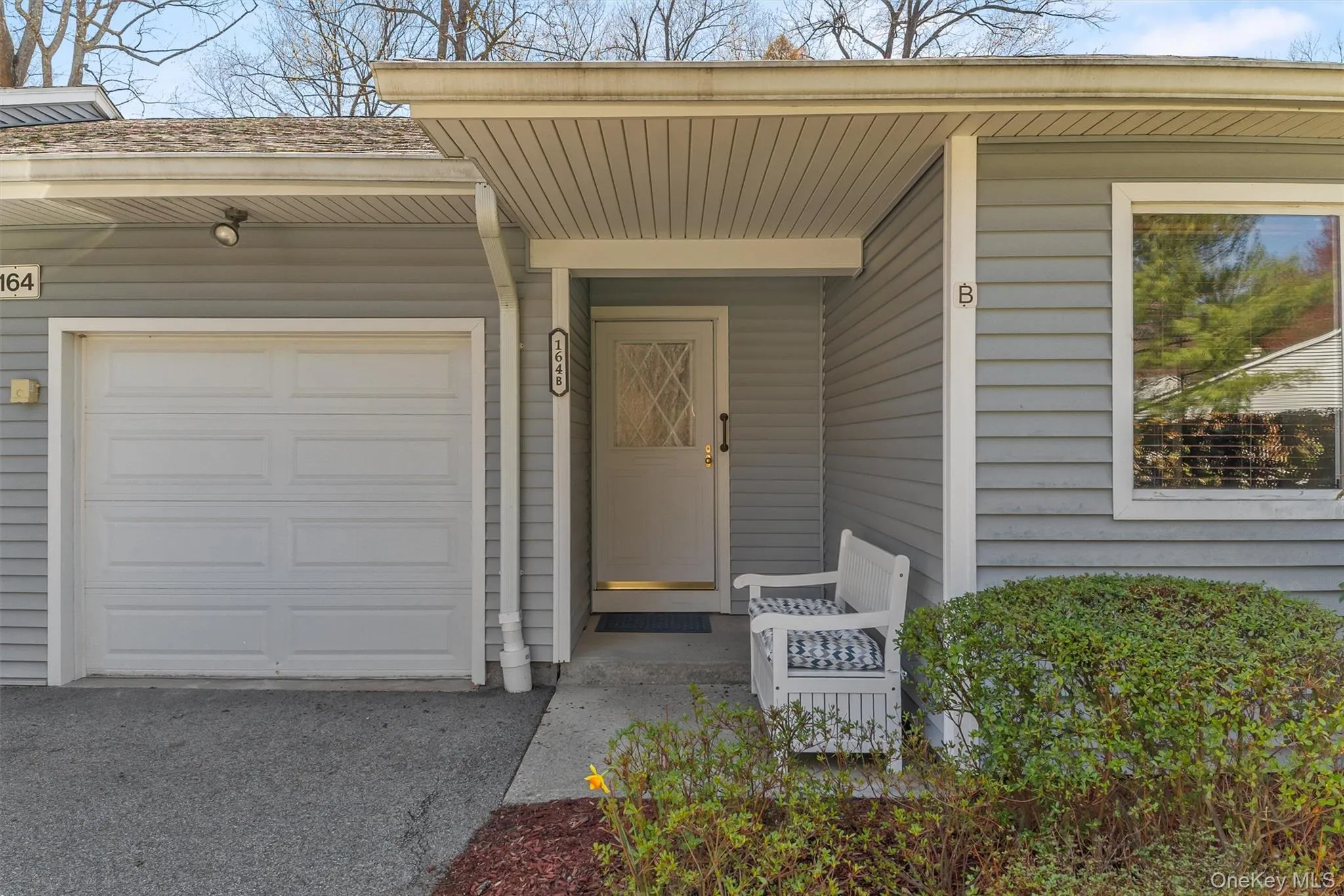 164 Carriage Ct front entrance with overhang, attached garage, and charming sitting bench area. 164 Carriage Ct front entrance with overhang, attached garage, and charming sitting bench area.