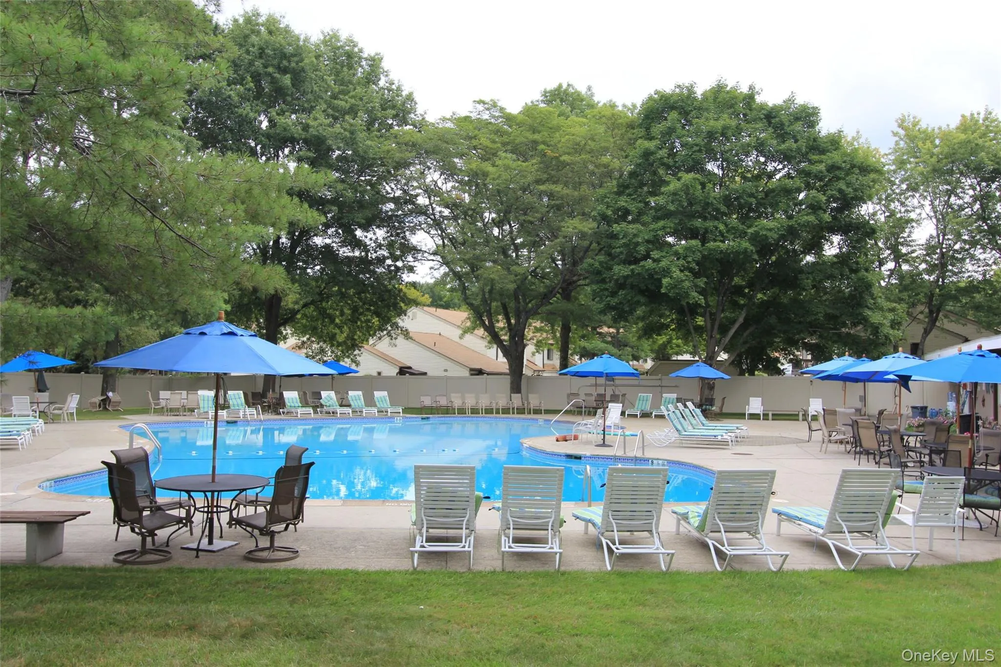 Pool with a patio area, and green space with tables and chairs for outdoor lunches. Pool with a patio area, and green space with tables and chairs for outdoor lunches.