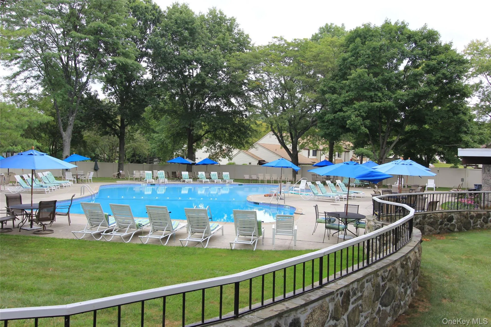 Pool featuring lounge chairs, tables and umbrellas. Pool featuring lounge chairs, tables and umbrellas.