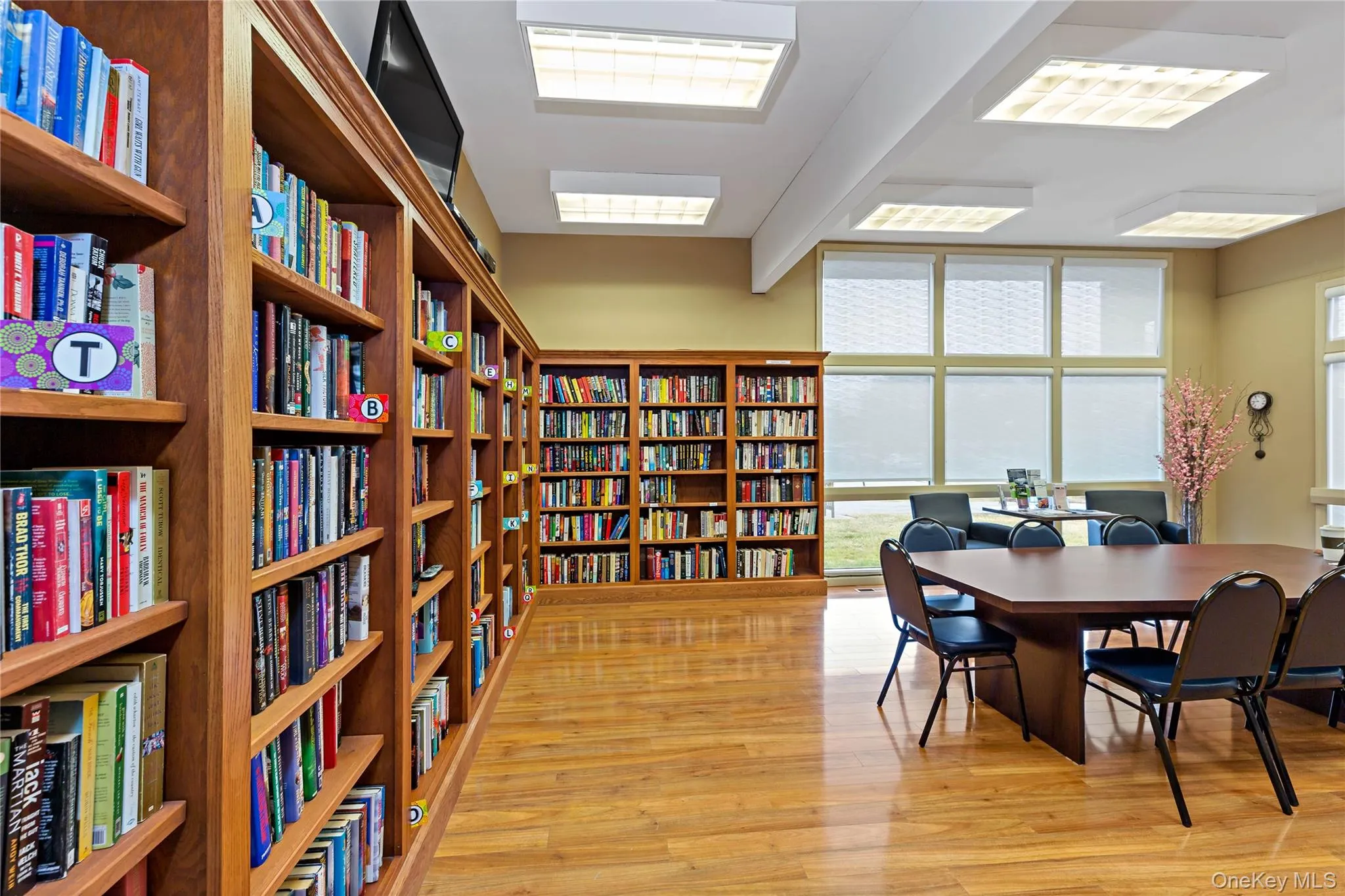 Library/Meeting room featuring bookshelves and light wood-style floors. Library/Meeting room featuring bookshelves and light wood-style floors.