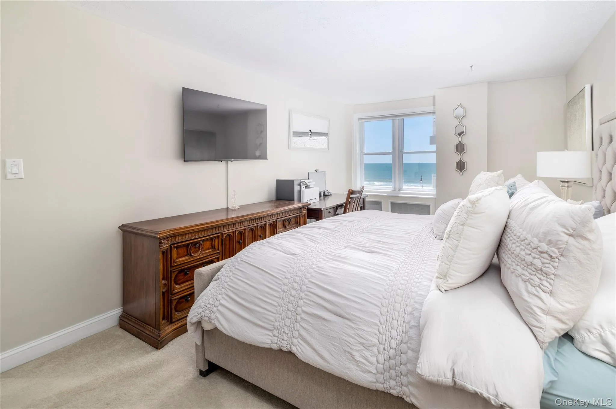 Bedroom featuring light colored carpet, baseboards, and a desk Bedroom featuring light colored carpet, baseboards, and a desk