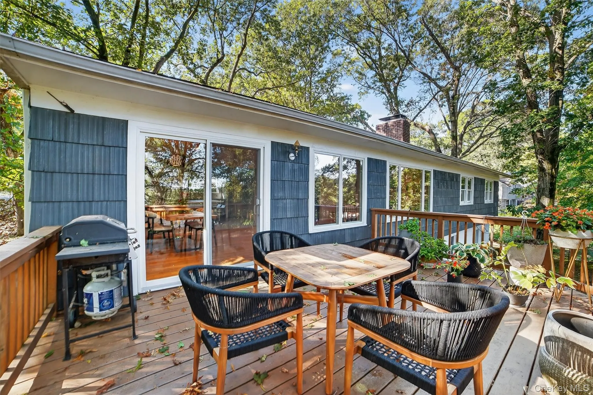Wooden terrace featuring outdoor dining area and grilling area Wooden terrace featuring outdoor dining area and grilling area