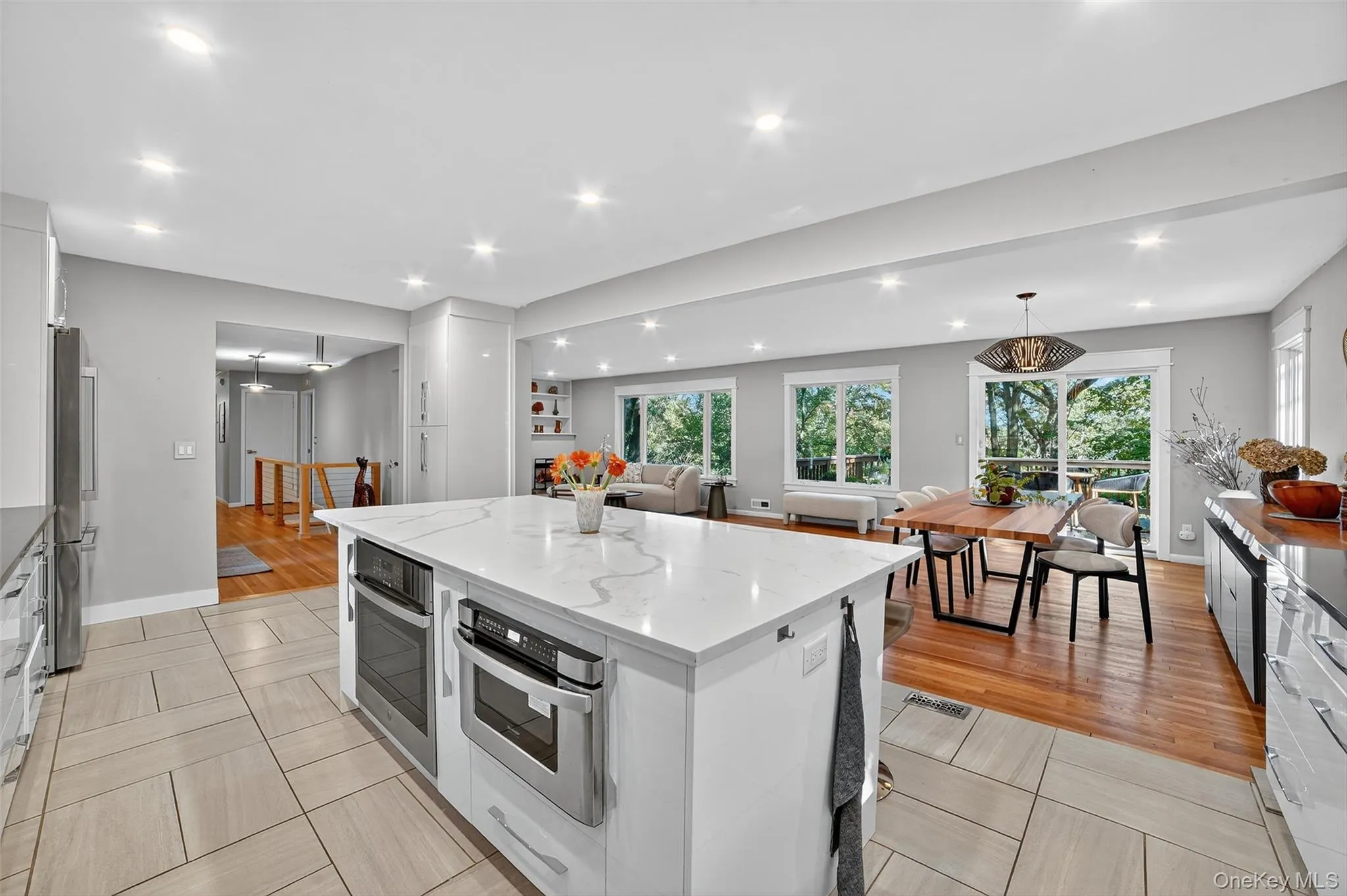 Kitchen featuring hanging light fixtures, light stone counters, white cabinets, recessed lighting, and a center island Kitchen featuring hanging light fixtures, light stone counters, white cabinets, recessed lighting, and a center island