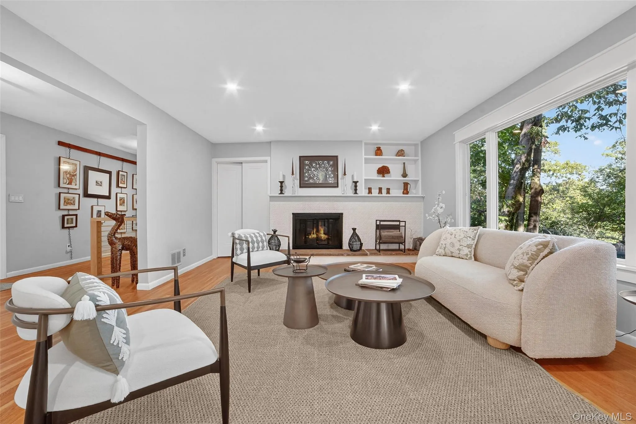 Living area with light wood finished floors, a fireplace, recessed lighting, and built in shelves Living area with light wood finished floors, a fireplace, recessed lighting, and built in shelves