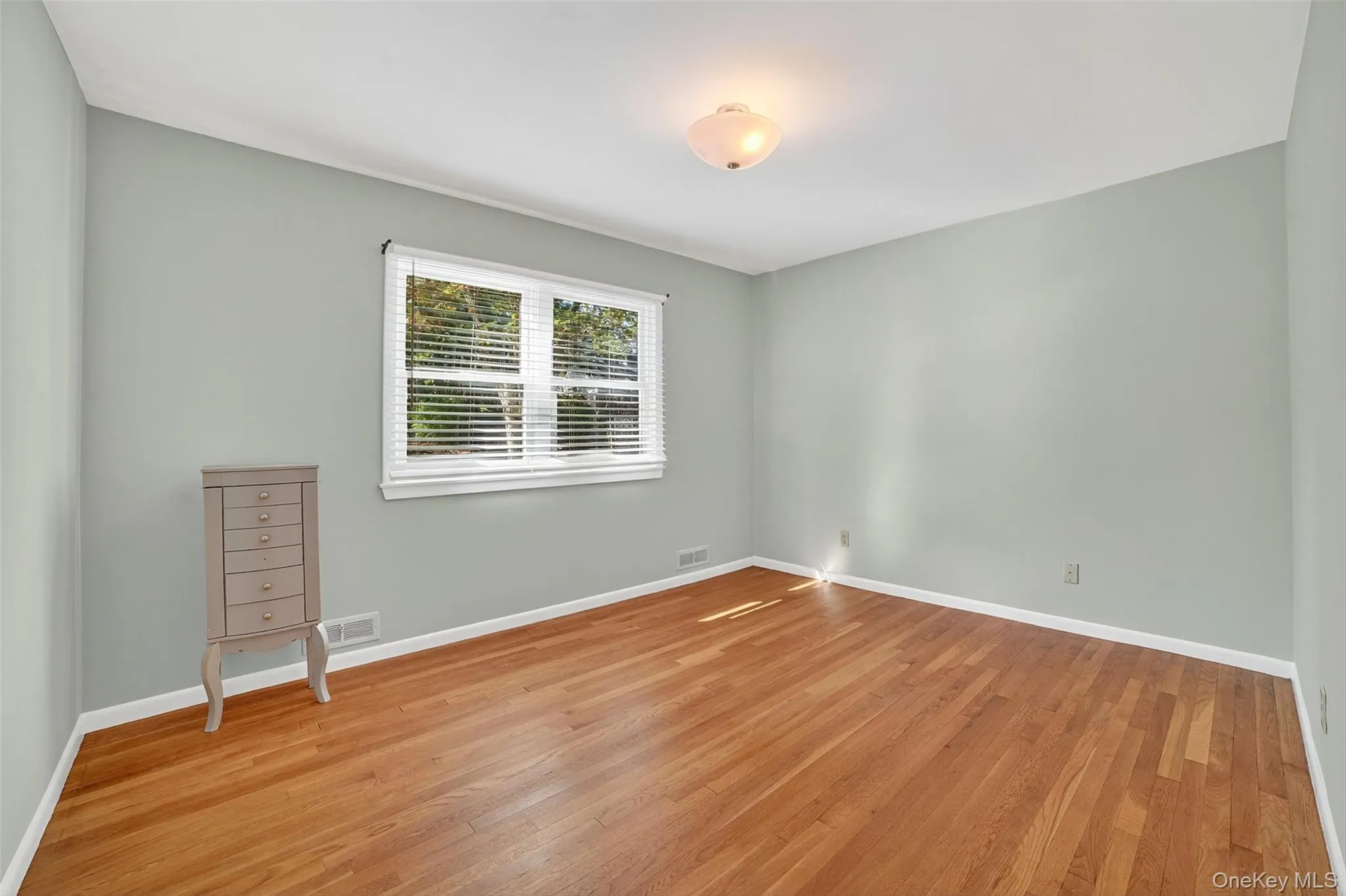Spare room with light wood-type flooring and baseboards Spare room with light wood-type flooring and baseboards