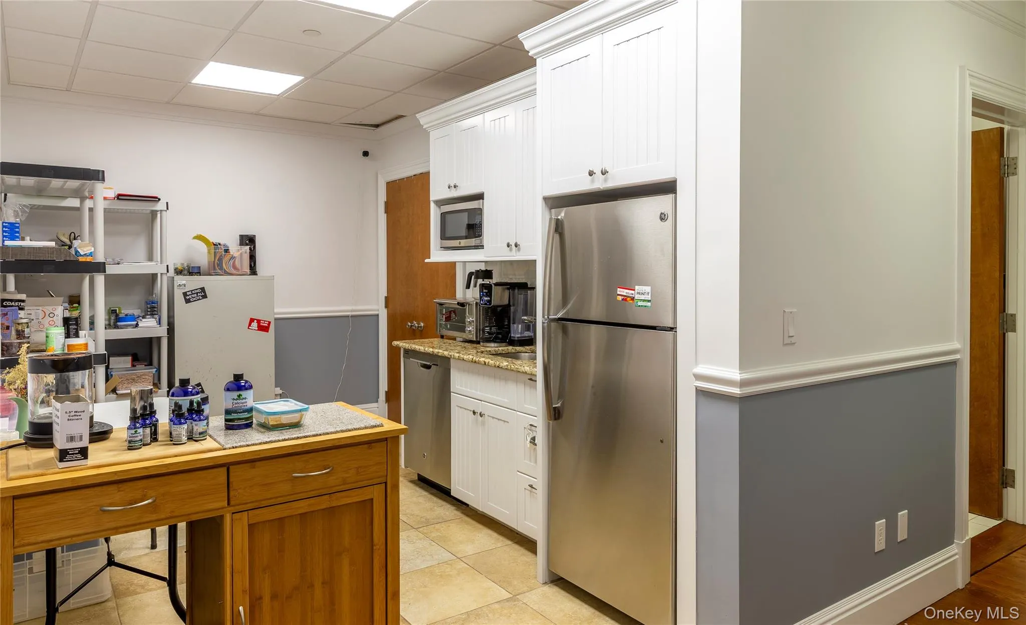 Kitchen with SS appliances including a full-sized refrigerator, dishwasher, and microwave. Crisp white custom cabinetry, granite countertops, and space for a table for a break area. Kitchen with SS appliances including a full-sized refrigerator, dishwasher, and microwave. Crisp white custom cabinetry, granite countertops, and space for a table for a break area.