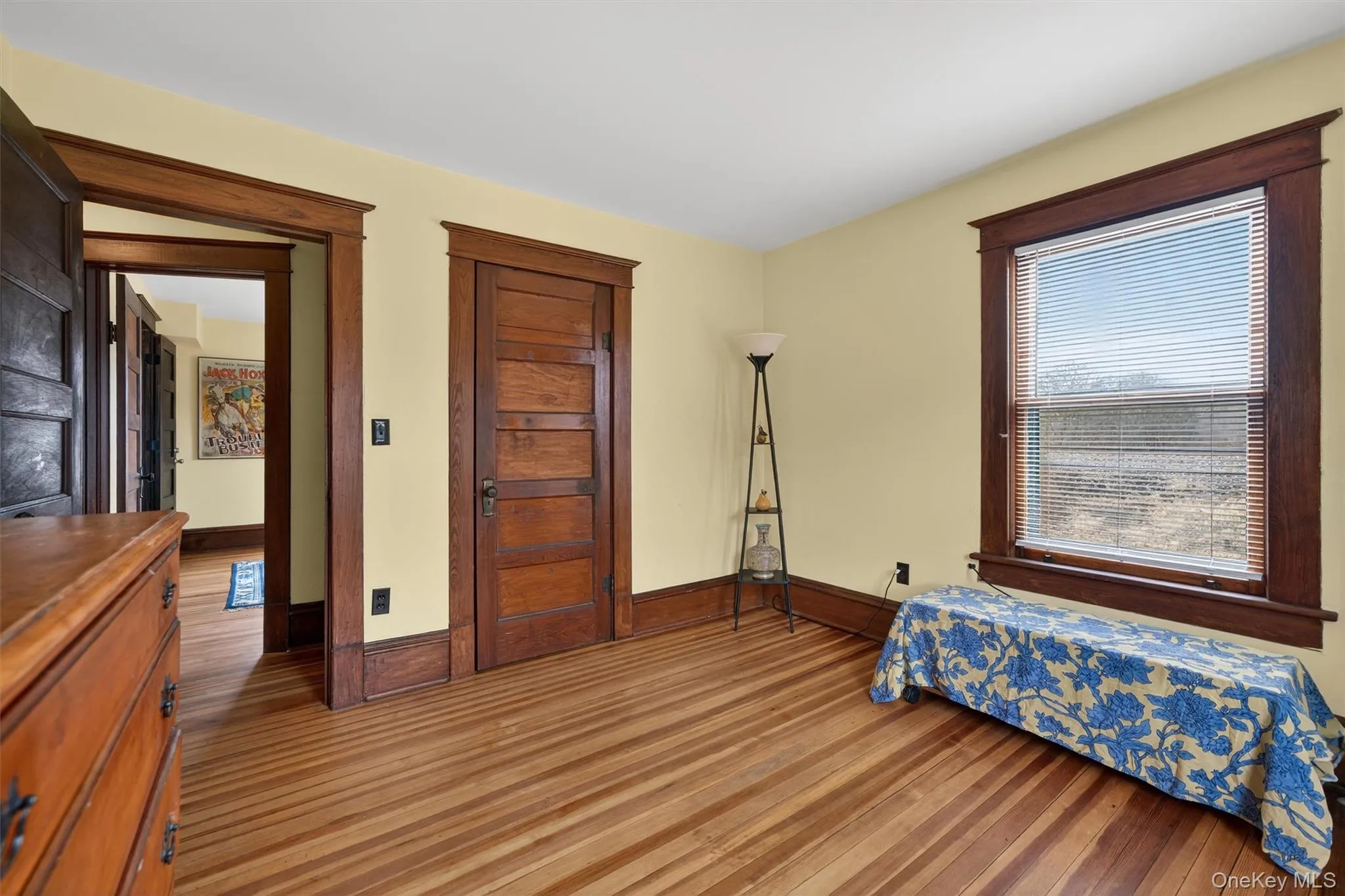 Bedroom featuring dark wood-style flooring and baseboards Bedroom featuring dark wood-style flooring and baseboards