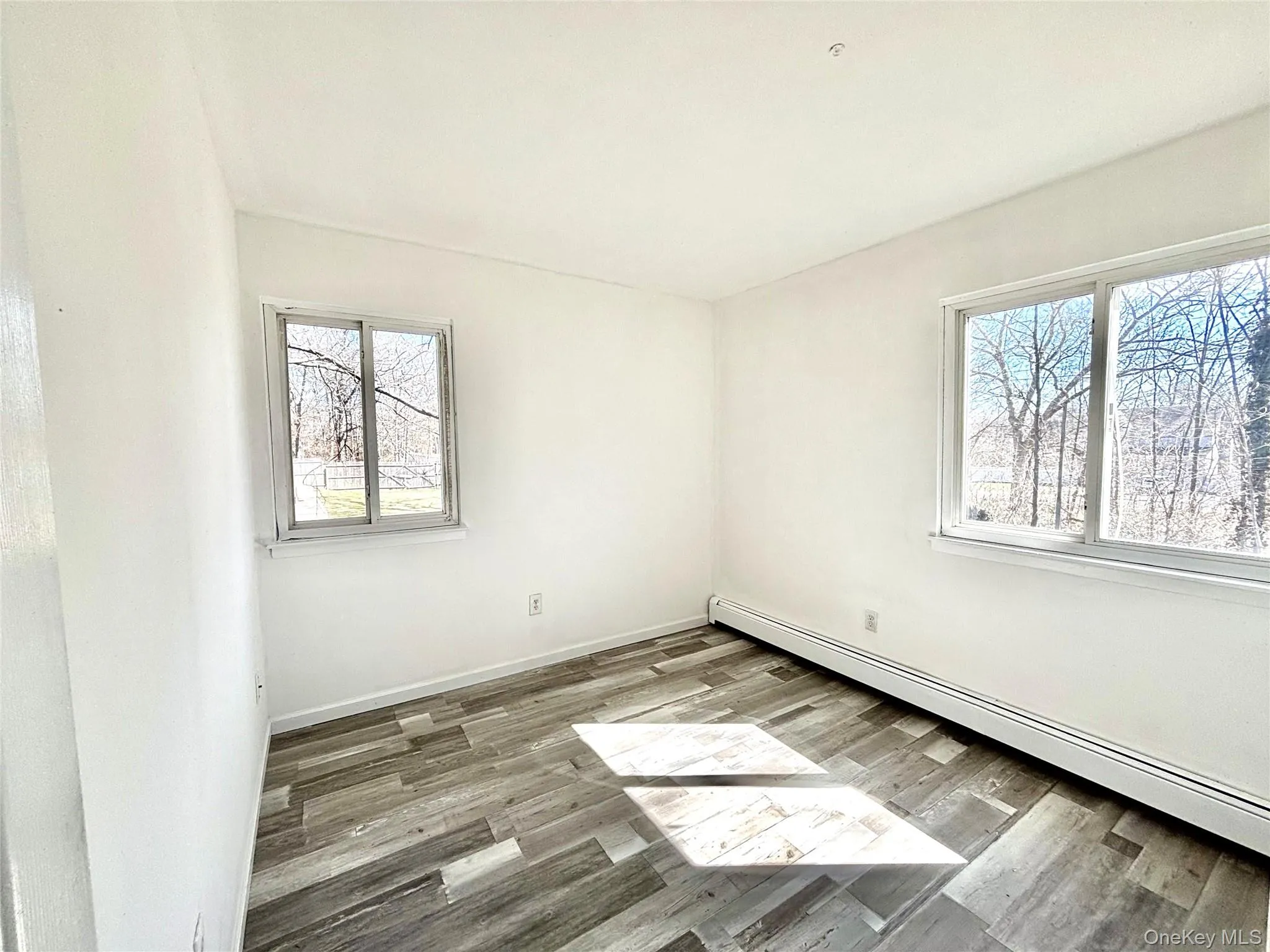 Second bedroom with a baseboard, radiator and vinyl wood-style floors Second bedroom with a baseboard, radiator and vinyl wood-style floors