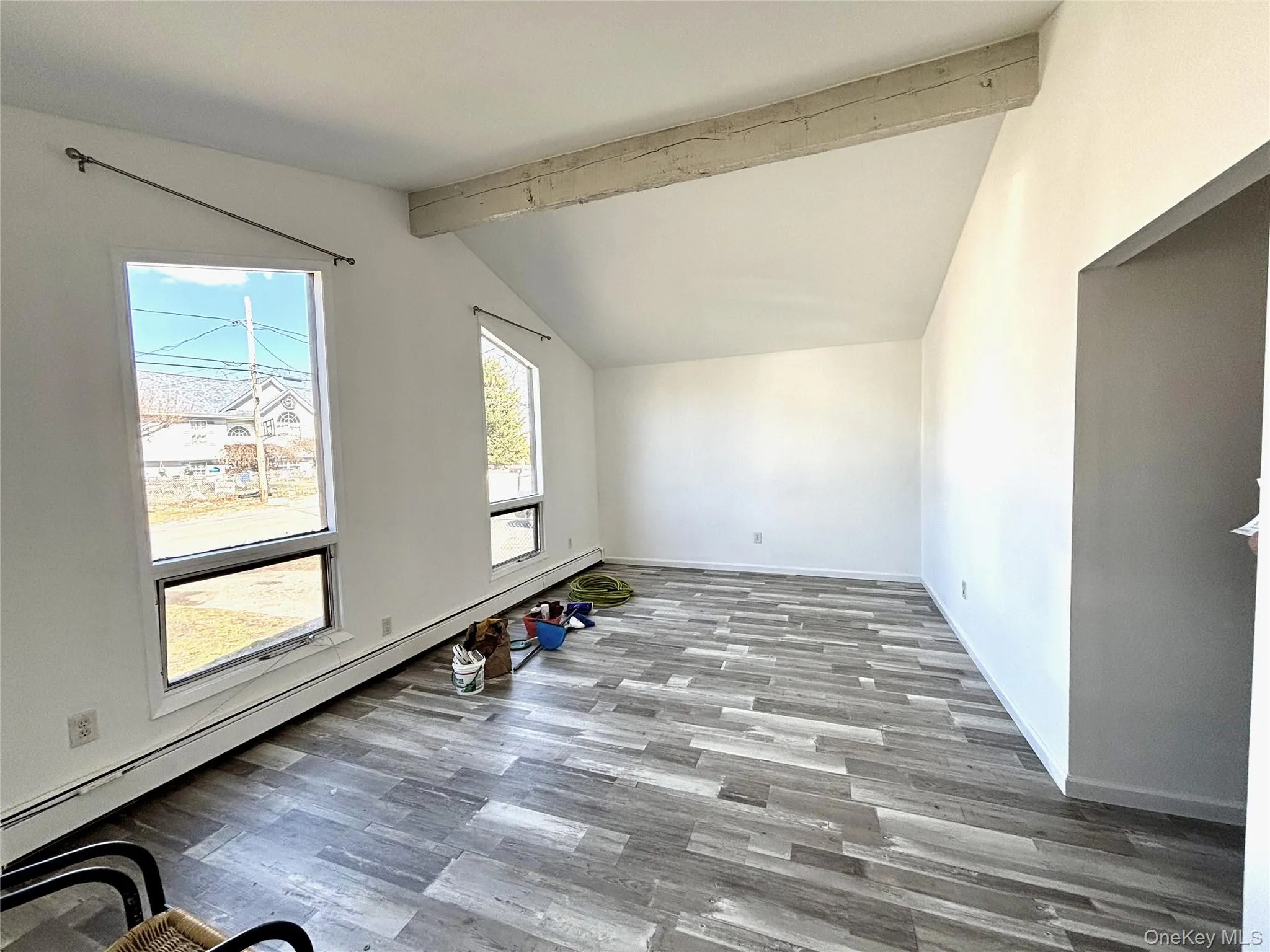 Living Room featuring a baseboard heating unit, vaulted ceiling and vinyl wood-style floors Living Room featuring a baseboard heating unit, vaulted ceiling and vinyl wood-style floors
